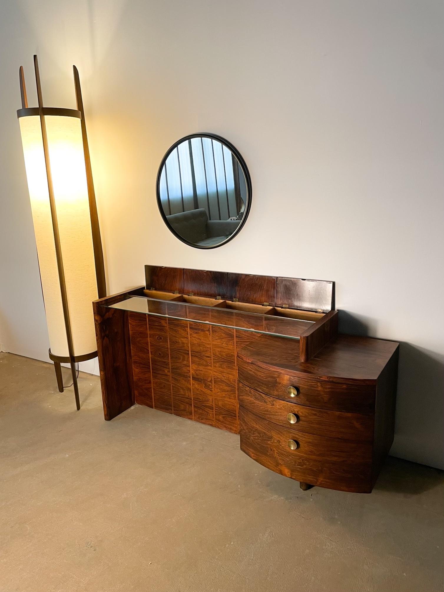 This Brazilian rosewood vanity is a stunning item from Gilbert Rohde’s 3707 series for Herman Miller, produced in 1937. Rohde’s sublime early modern stylings of minimalist planes, floating volumes, and simple but refined details are all on display