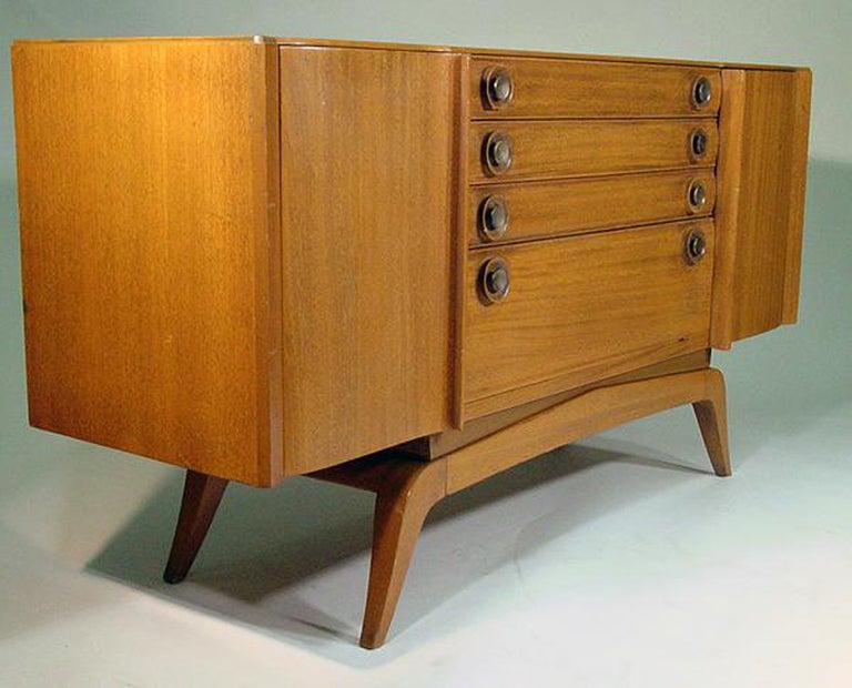 This 1940s buffet by modern Pioneer, Gilbert Rohde (1894–1944), for Brown Saltman features solid blond mahogany construction embellished with decorative brass pulls. The piece boasts plenty of storage including three stacked doors surmounting a