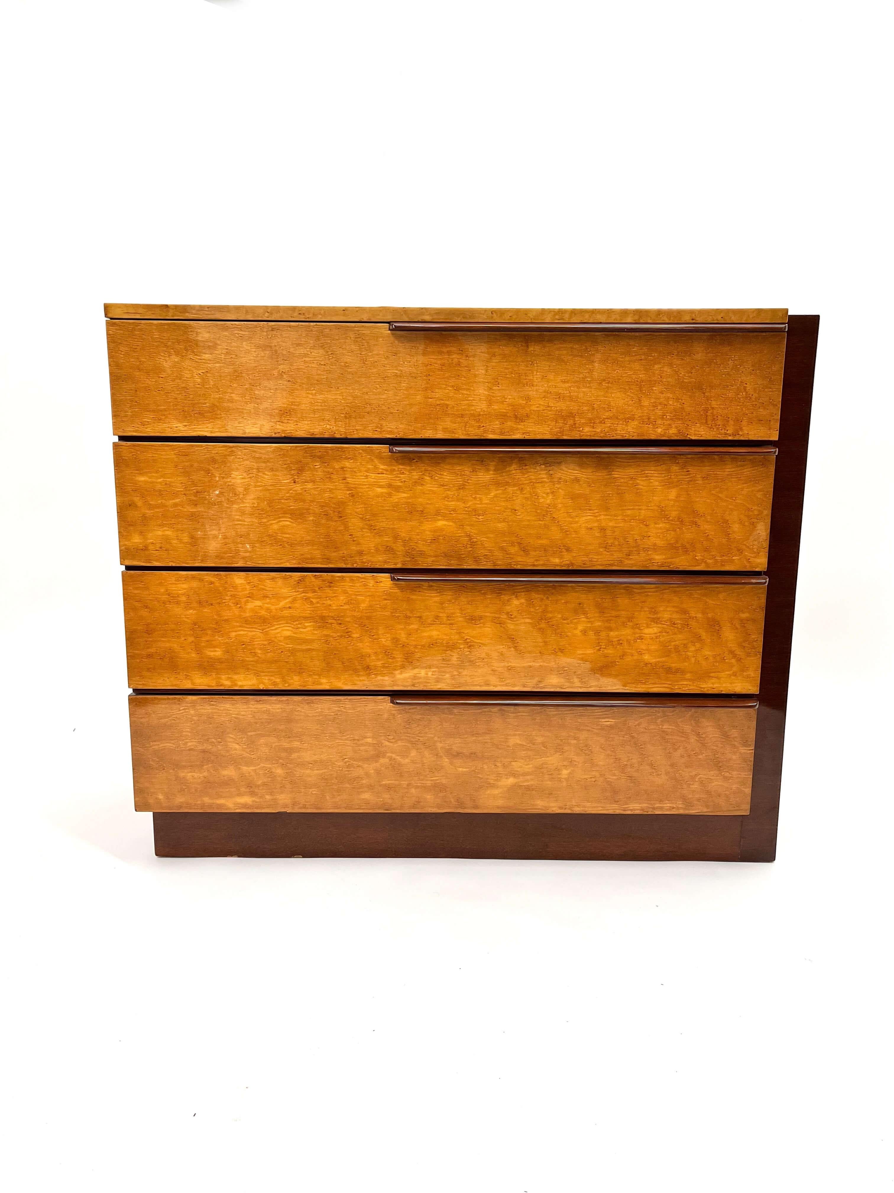 Gilbert Rhode designed this gorgeous and highly glossed dresser is executed in birdseye maple and maghogany. It has the perfect balance of mid century modern simplicity and the fine craftsmanship and rich materials characteristic of the Art Deco