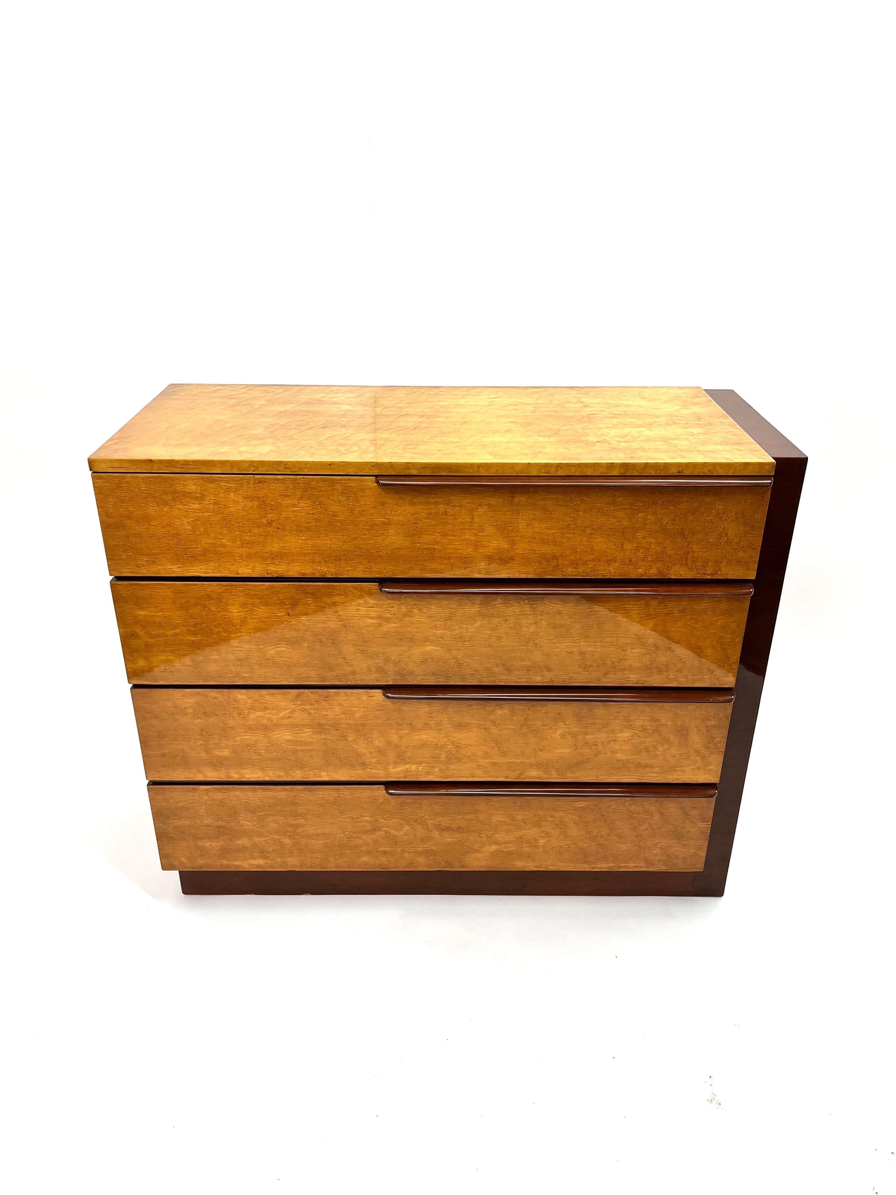 Gilbert Rhode designed this gorgeous dresser  in birdseye maple and mahogany. It has the perfect balance of the fine craftsmanship and rich materials characteristic of the Art Deco era.  Lacquered birds eye maple represents luxury, glamour, and