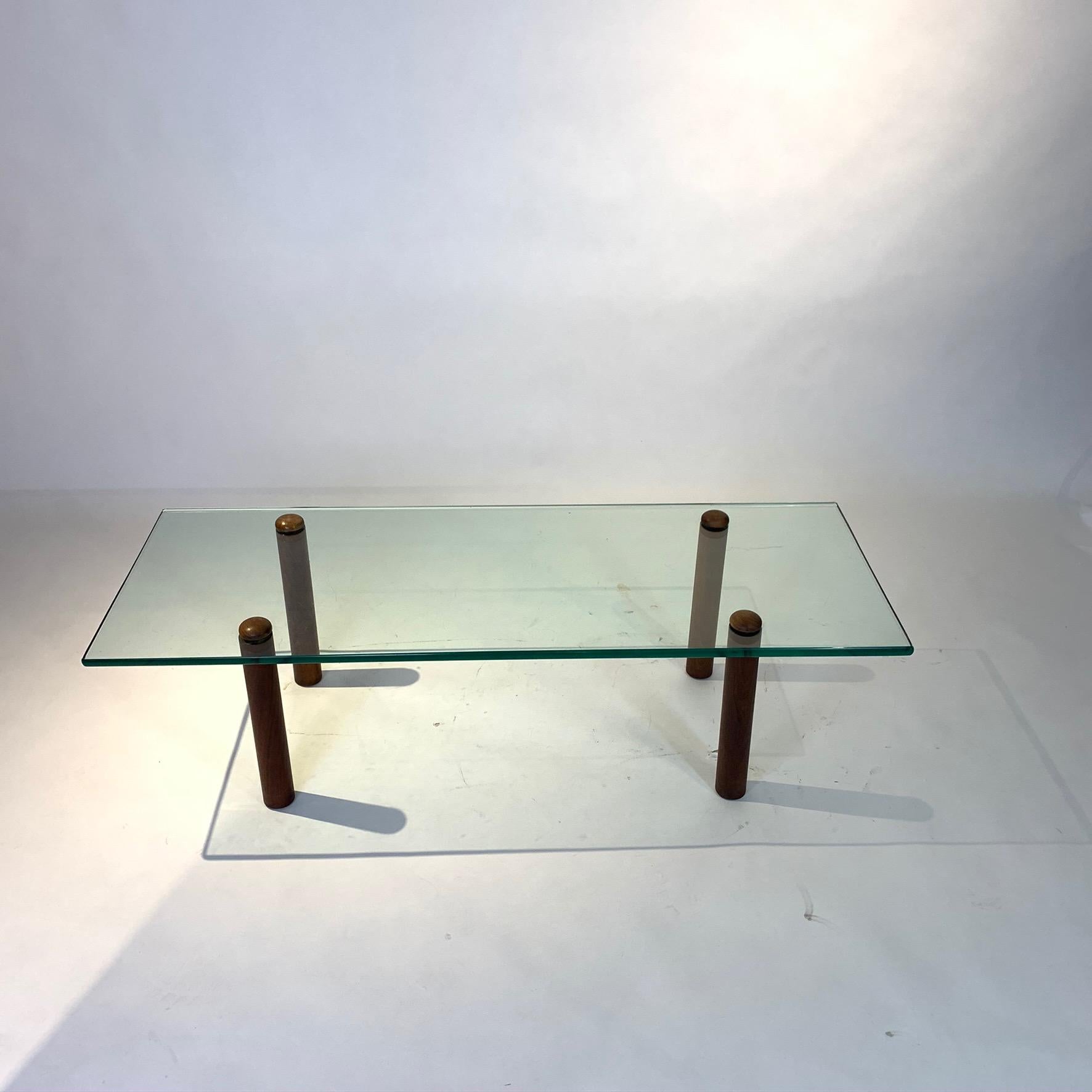 A very Classic yet simple coffee table designed by Gilbert Rohde for Herman Miller from the early 1940s. Walnut legs support thick green edged glass that has a floating effect. This table would work well with Classic Art Deco, Machine Age, or