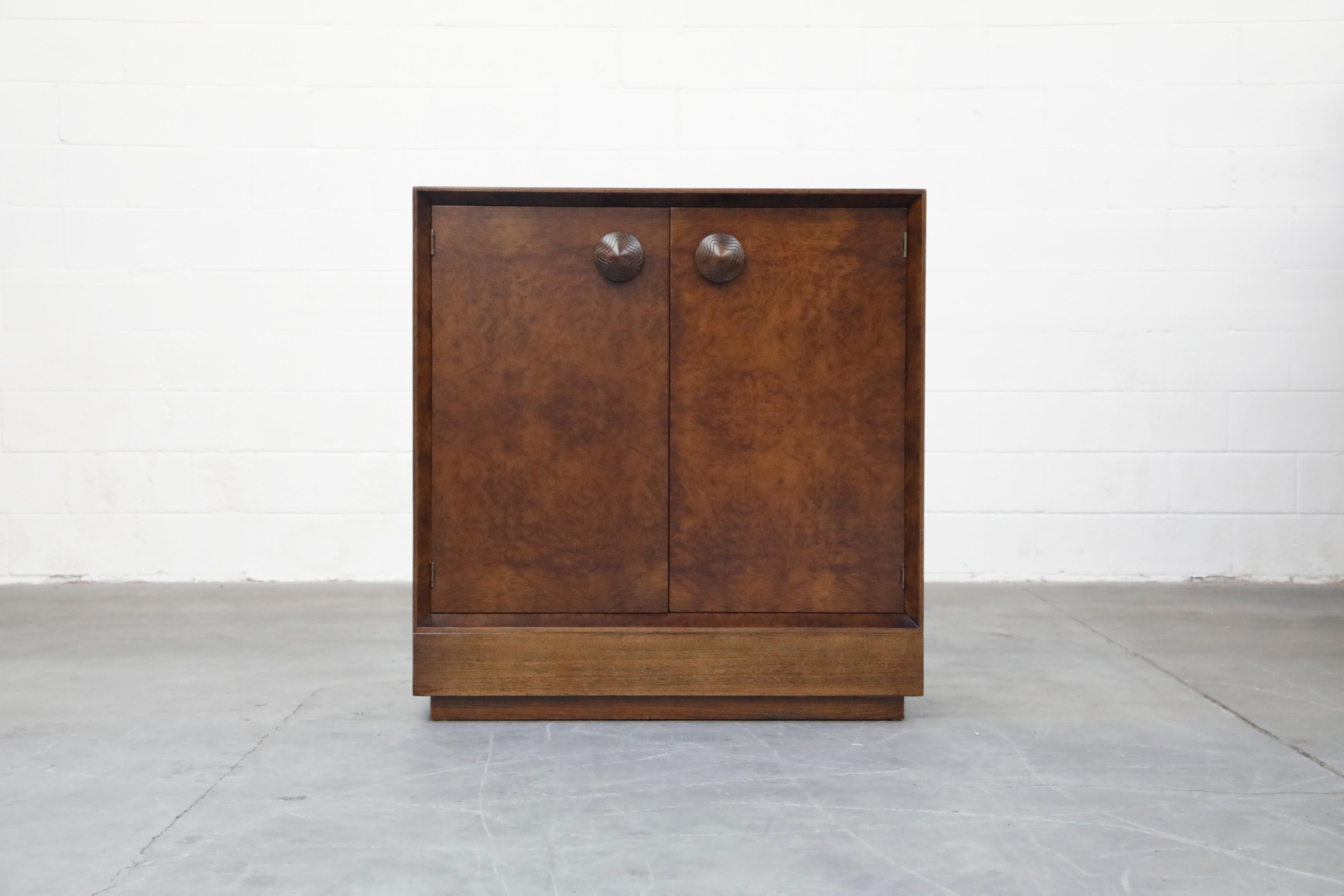 This fully-restored Classic and collectible burl wood dresser cabinet by Gilbert Rohde for Herman Miller was part of his 1941 'Paldao' line of streamline modernist and modular furniture. This two-door cabinet is most notable for its distinctive