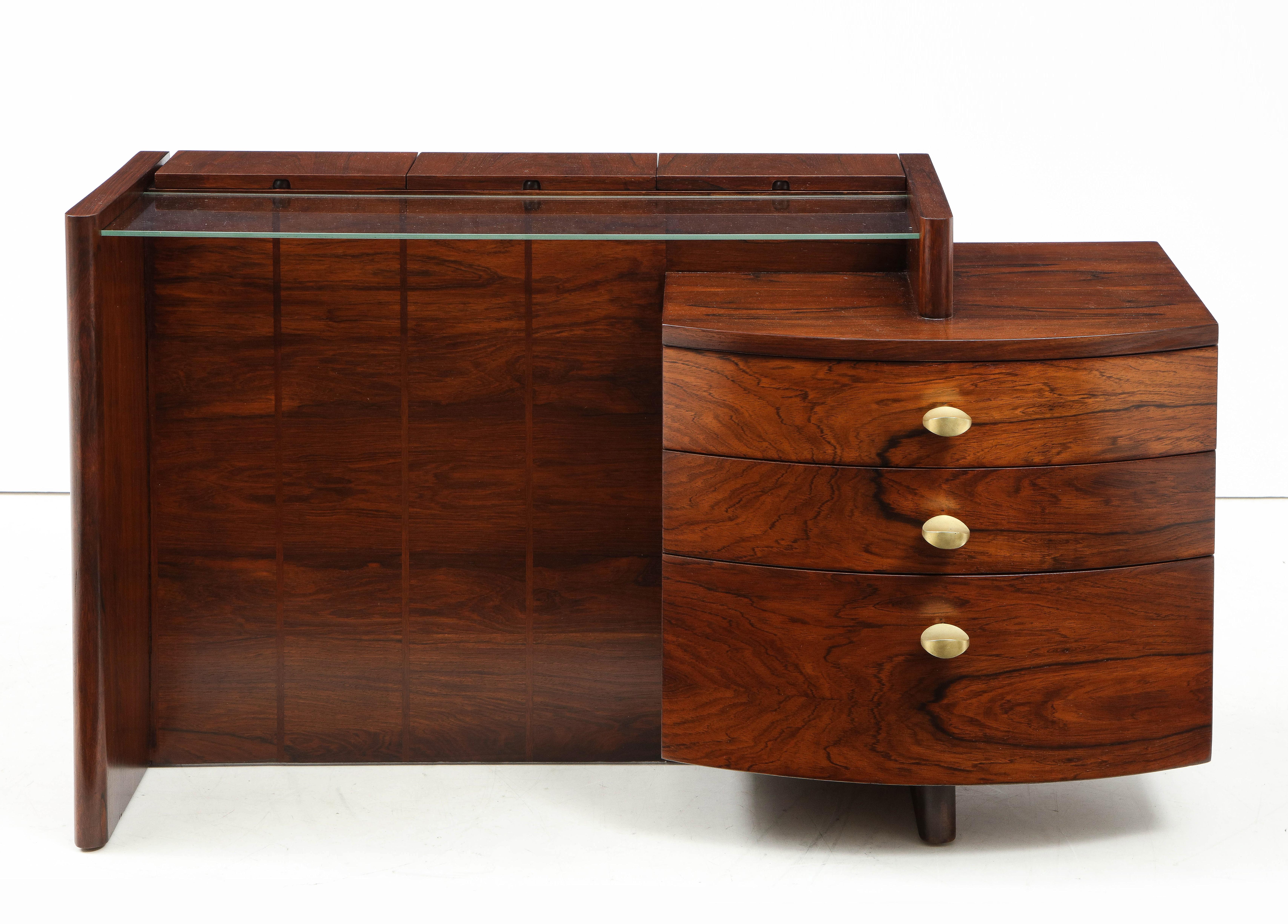 Stunning 1940s Gilbert Rohde designed for Herman Miller Model number 3770 vanity, made of Brazilian rosewood with 3 drawers 3 small storage compartments and glass shelf.