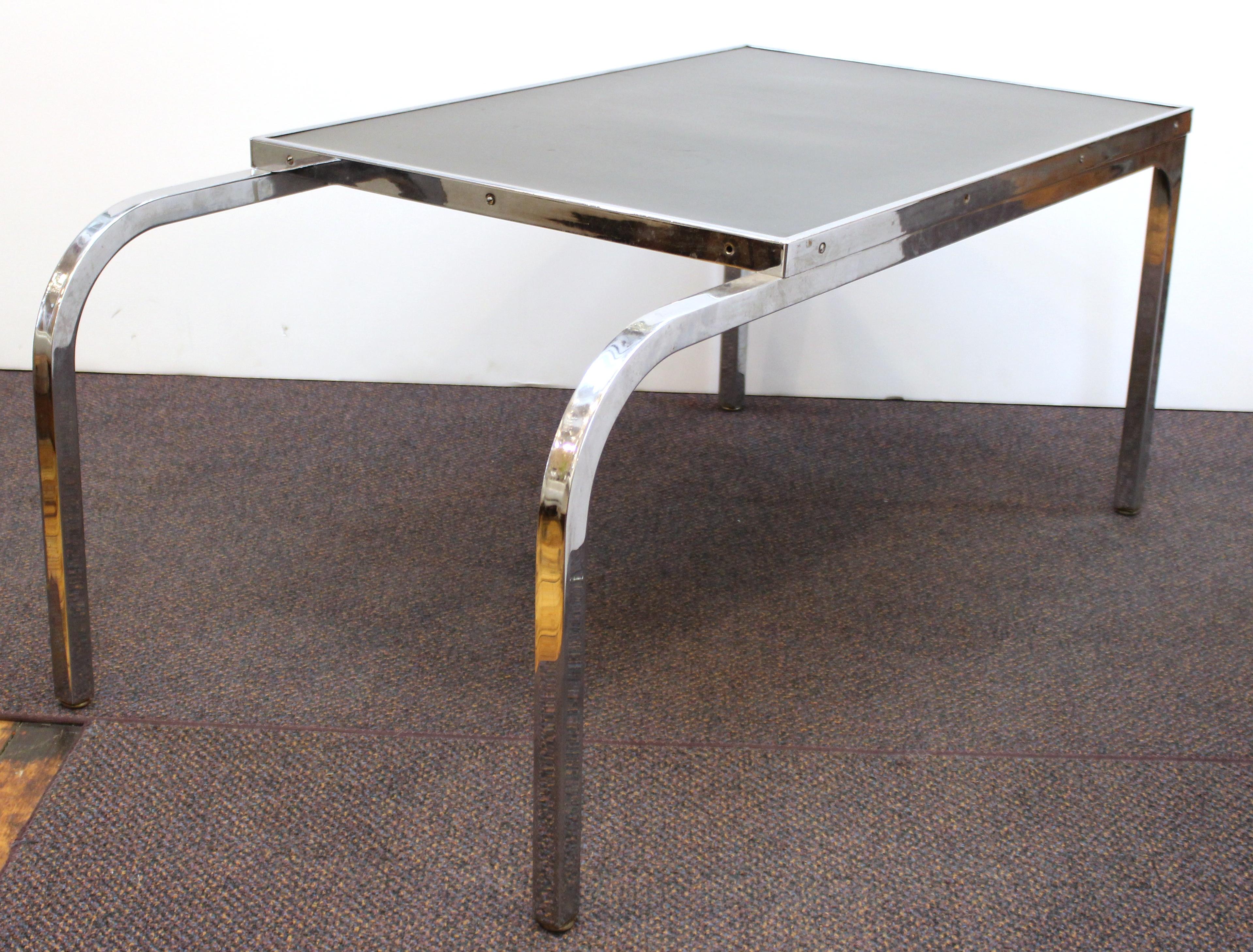 American Machine Age period chromed metal side table or end table designed by Gilbert Rohde for the Troy Sunshade Company. The piece was likely made in the 1930s in the United States and comes with a black formica top and curved front legs.
Label on