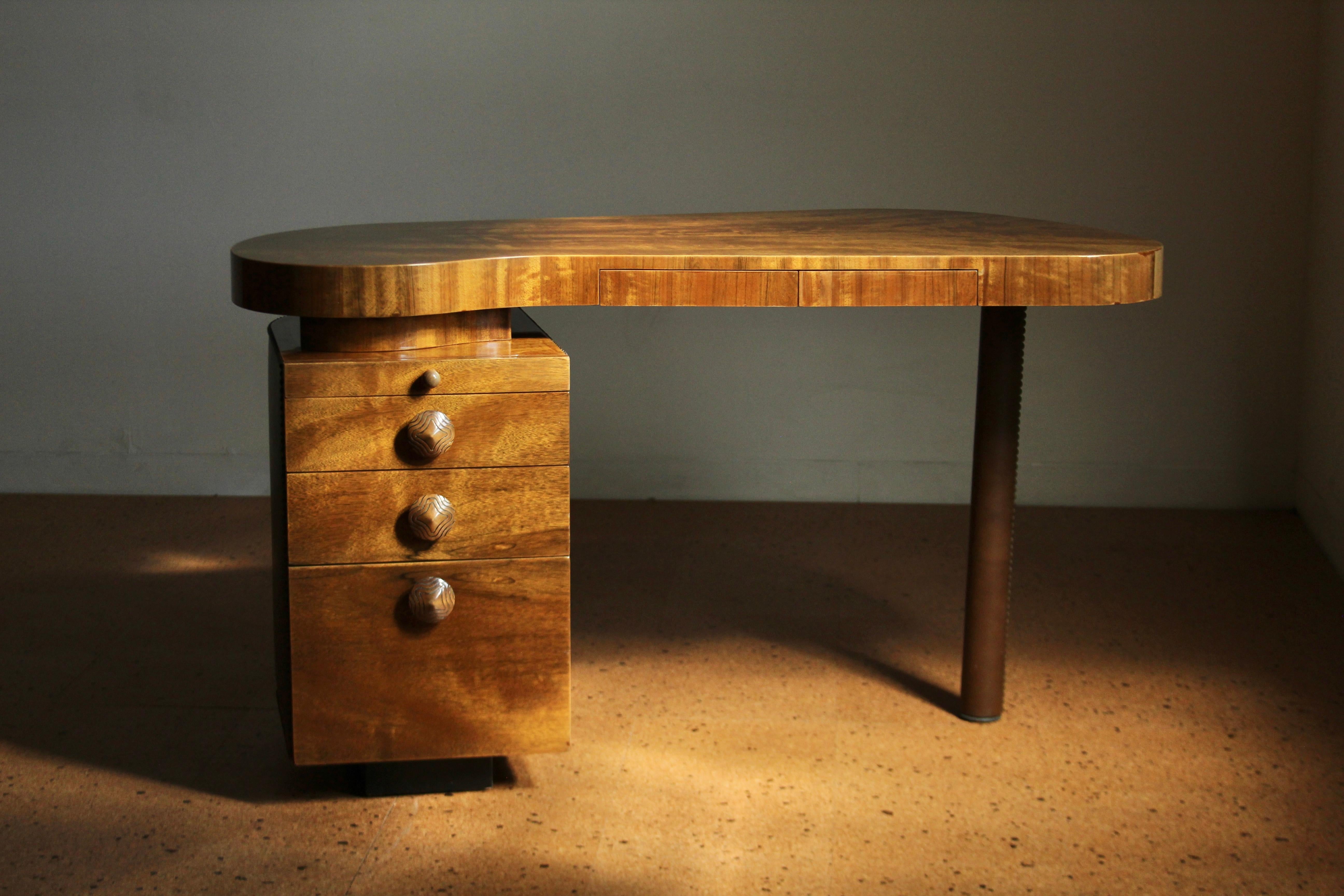 A Gibert Rohde designed “Ectoplastic” desk for Herman Miller, circa 1940s. Rohde designed this desk as part of the Paldao Group, a furniture suite named for the distinct wood with contrasting grain that appears on the desktop. The unique design of