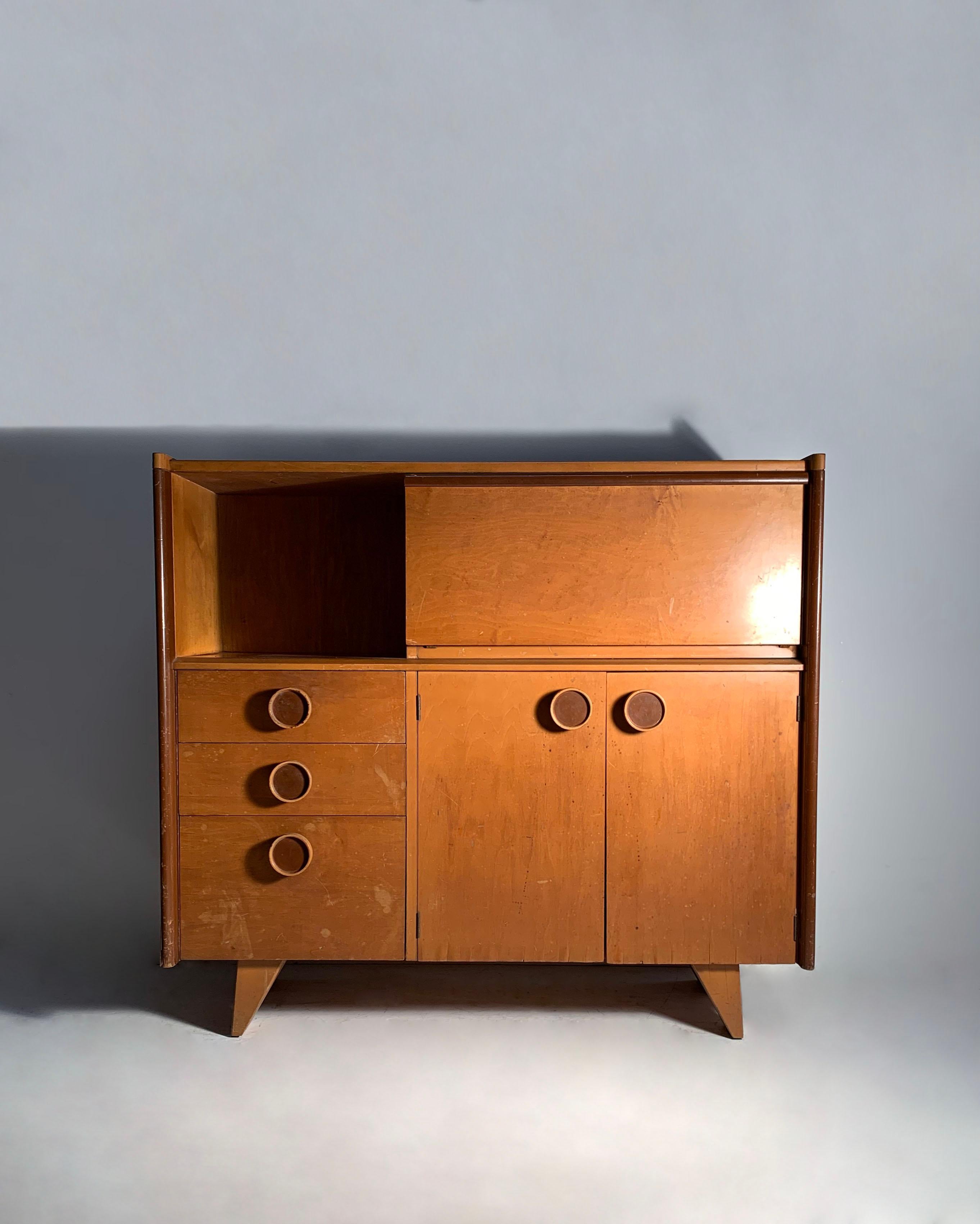 A rare cabinet by Gilbert Rohde on the petite side for scale. Model 4020 for Kroehler.   All the pieces from this collection were designed with space saving in a room in mind. The should make a very nice Bar Cabinet. 

Exhibited : 'America at Home'