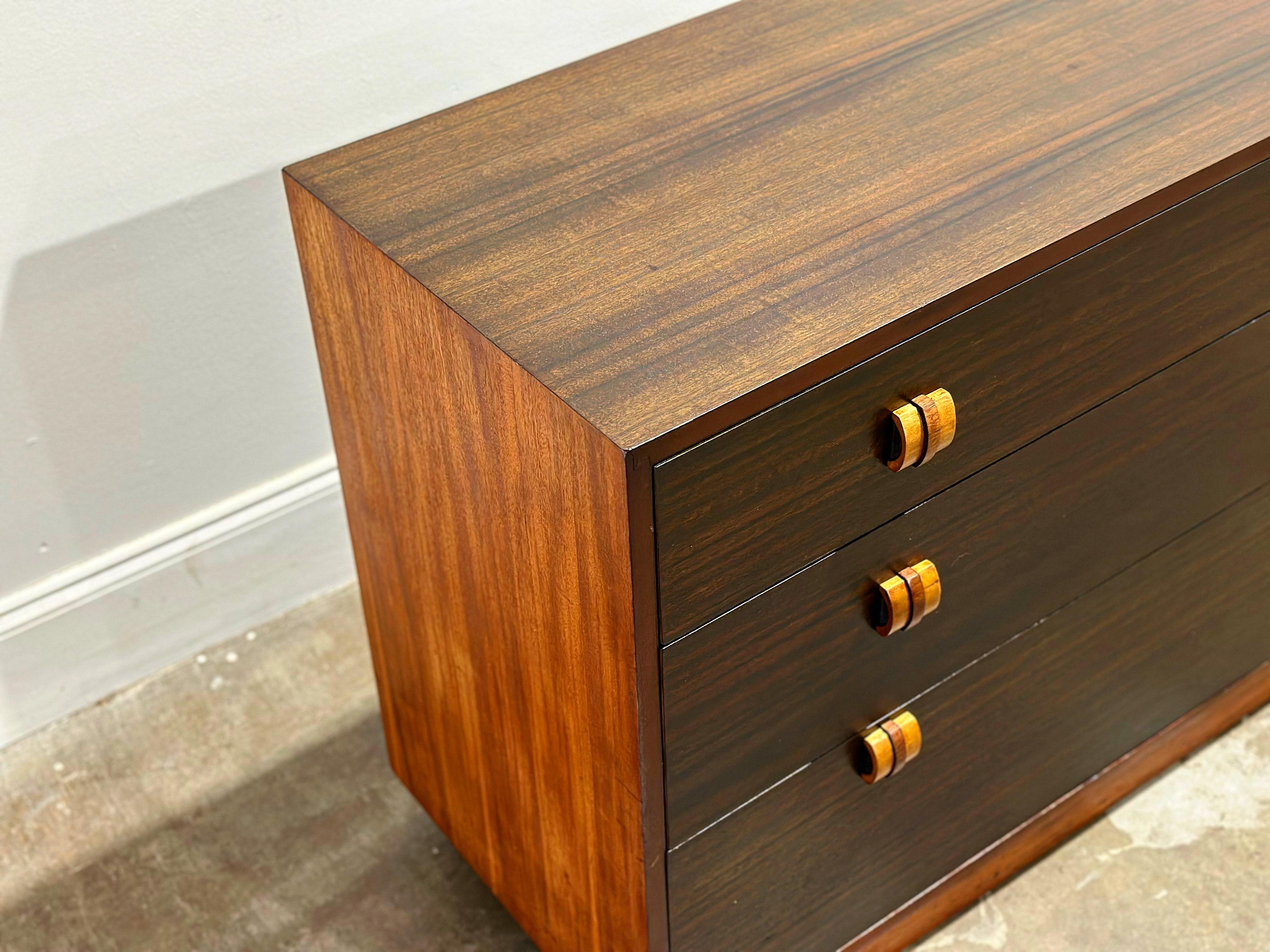 Rare Streamlined Moderne/Art Deco chest of drawers by Gilbert Rohde for Cavalier Furniture circa mid/late 1940s. Perfect juxtaposition of woods - afromasia case with a wenge top and drawer facades. Solid birch plinth base with sculpted afromasia and