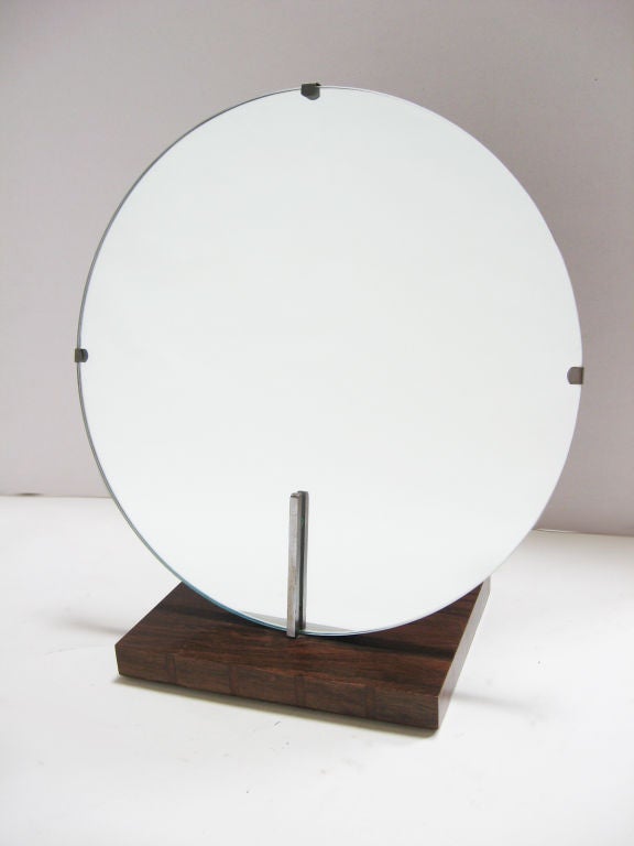 A beautiful Gilbert Rohde design by Herman Miller. This vanity mirror appears in the 1940 Herman Miller catalogue as part of the No. 3770 bedroom group. The base is Brazilian rosewood with mahogany inlays. The mirror is in excellent original