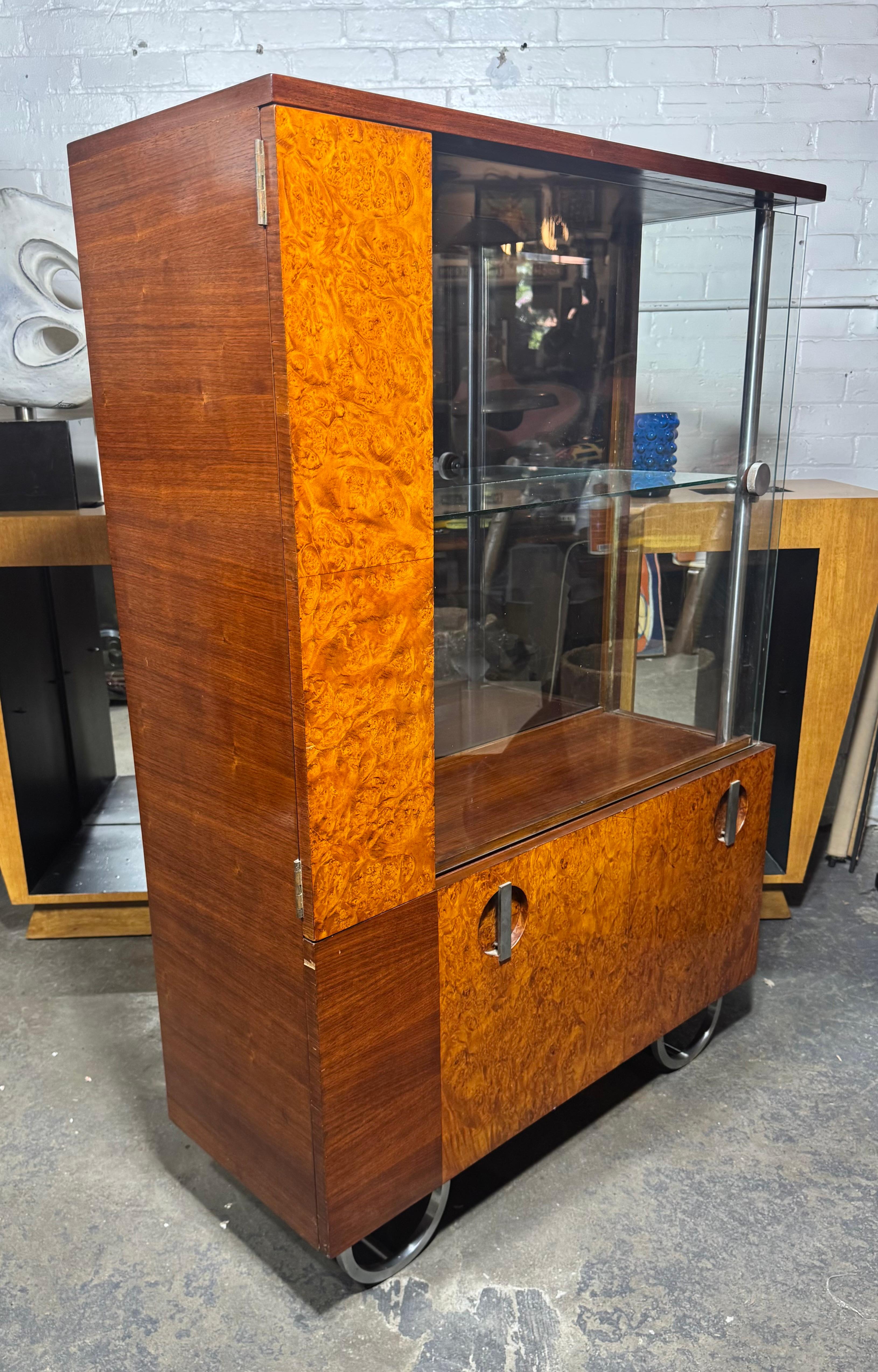 Questo mobile asimmetrico in stile Art Déco... DISPLAY o BAR.  è stato progettato da Gilbert Rohde per Herman Millet nel 1933. Il legno è noce e radica di noce con una base a doppia 