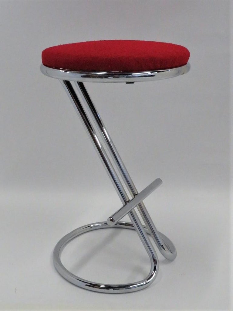 Designer Gilbert Rohde created this chrome counter height bar stool in 1933.  It has been professionally re-chromed and the tomato red boucle upholstery is recent. He worked for companies such as Herman Miller and Heywood-Wakefield. Troy Sunshade
