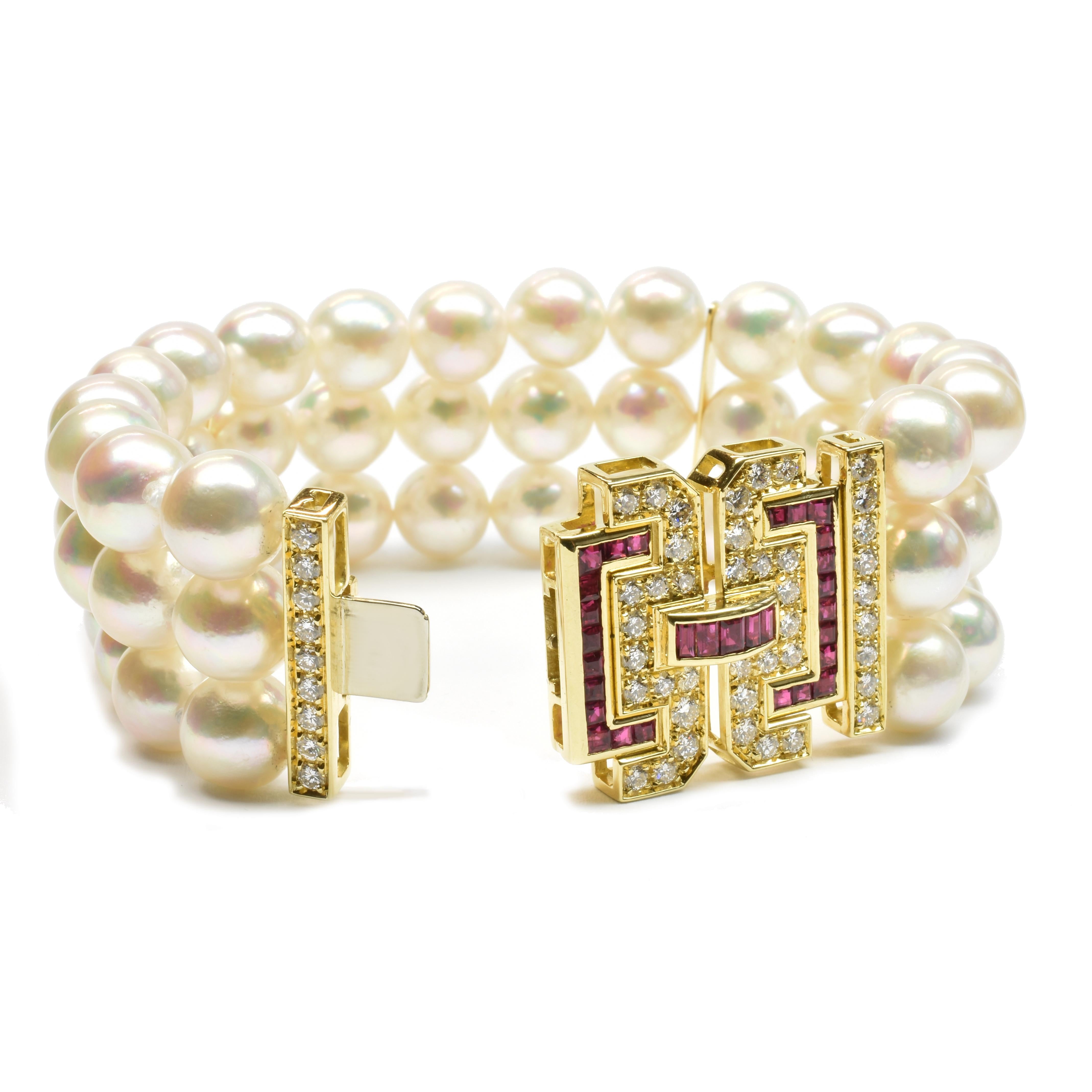 18Kt Yellow Gold Bracelet with a triple row of 9.50 mm Japanese Cultured Natural Pearls Akoya. 
Top Quality Pearls with a high grade of roundness and color.
Unique Art Deco Style Clasp with Carrè Cut Natural Rubies and Round Cut Diamonds.
One of a