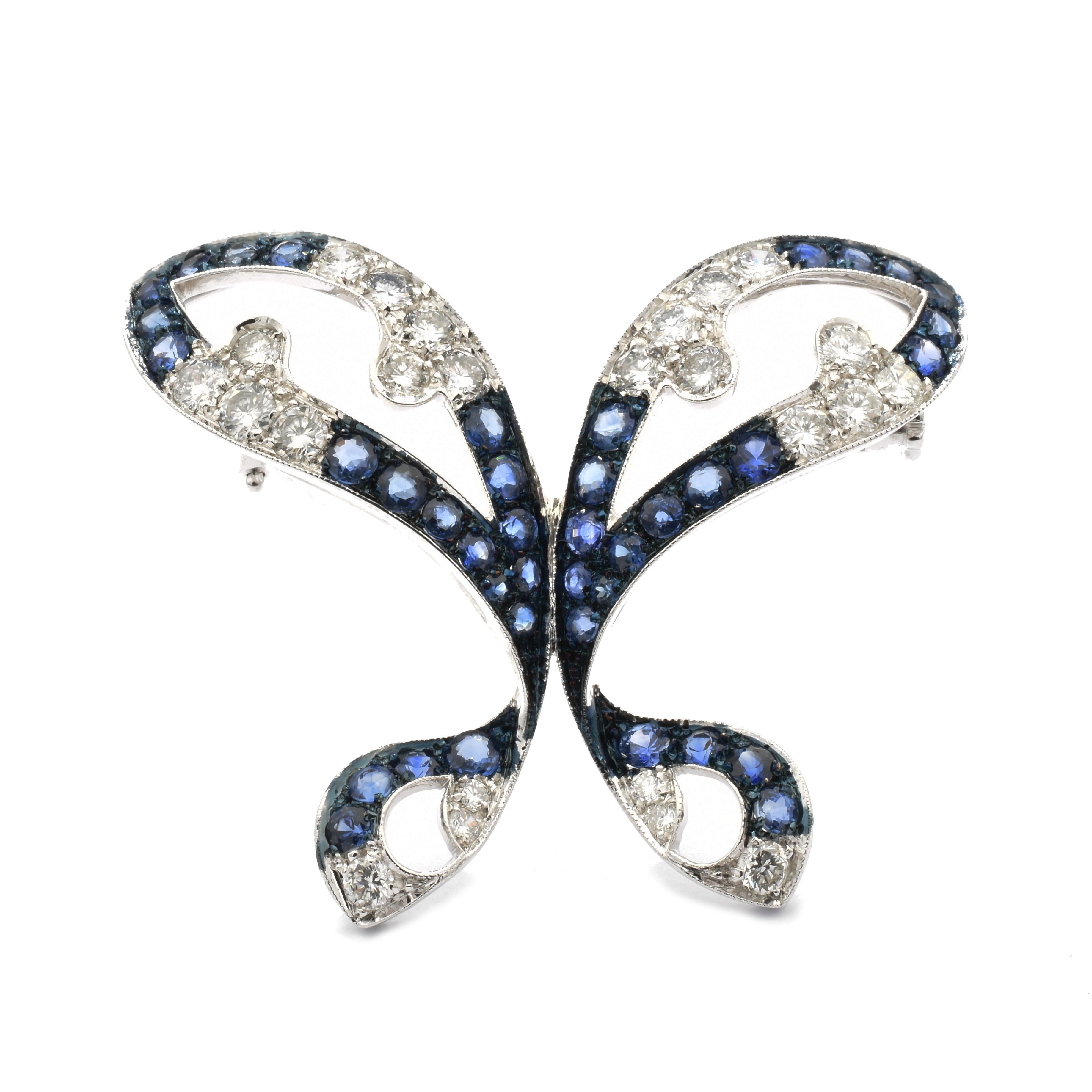Gilberto Cassola Schmetterlingsbrosche aus 18 Kt Weißgold mit weißen Diamanten und blauen Natursaphiren
Ein sehr einzigartiger Butterfly, der auf einem Kleid, einer Jacke oder auch einem Schal getragen werden kann. 
Handgefertigte