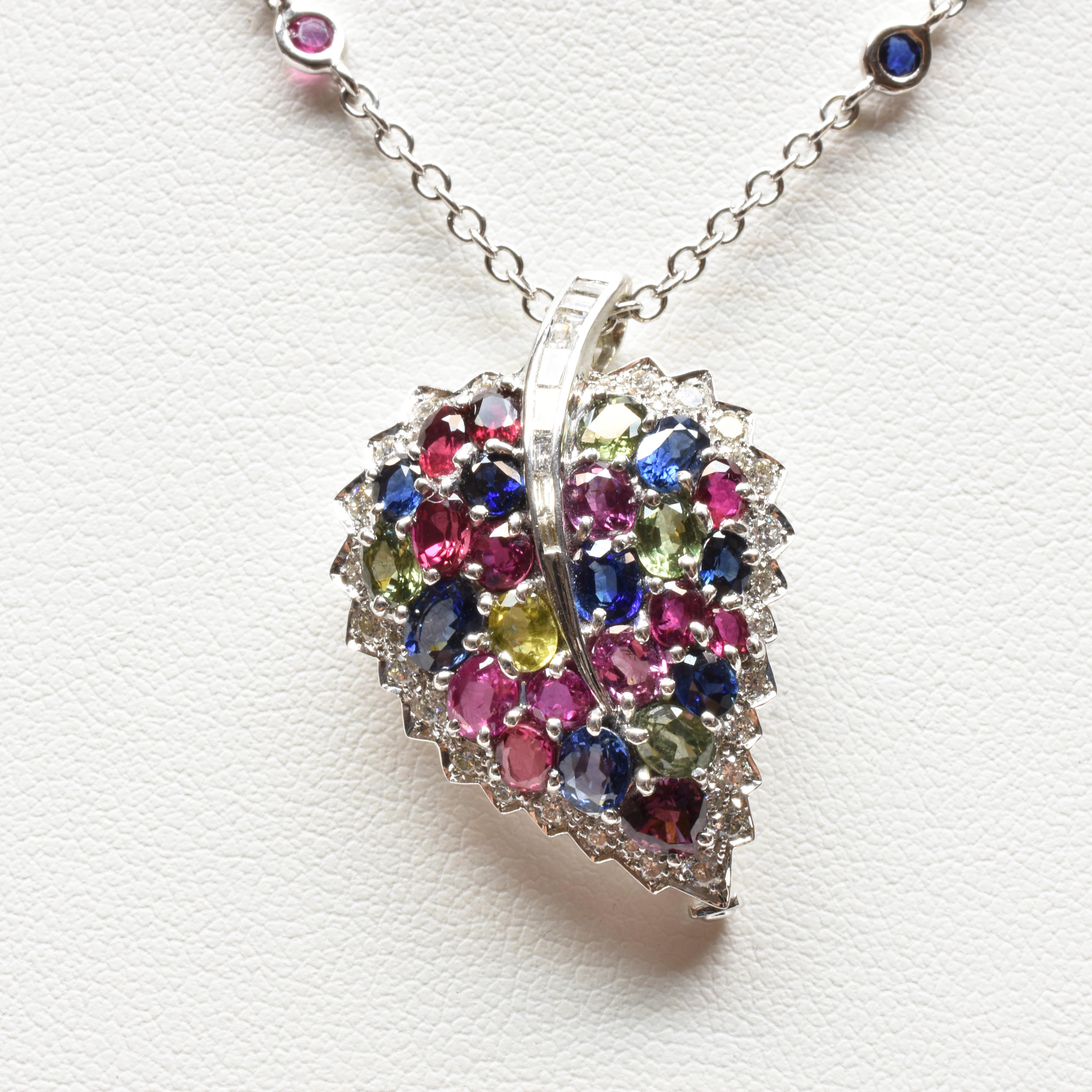 18Kt White Gold Leaf Pendant with Oval Shaped Natural Rainbow Sapphires, Round and Baguette Diamonds.
One of a Kind Piece. Handmade in our Atelier in Valenza Italy.
This Item can be used either as a Pendant or as a Brooch. The Brooch Pin has a