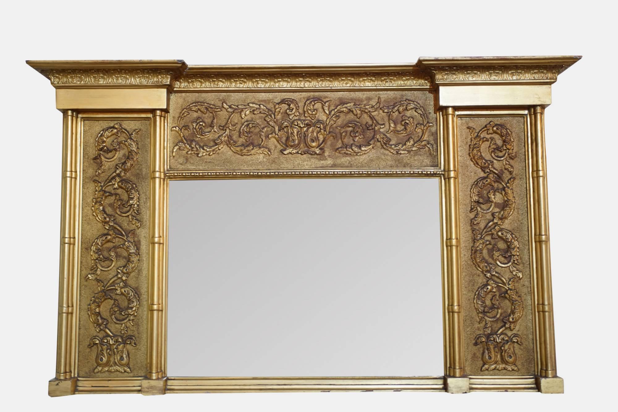 A gilded 19th century overmantel mirror with decorated panel and bevelled glass.