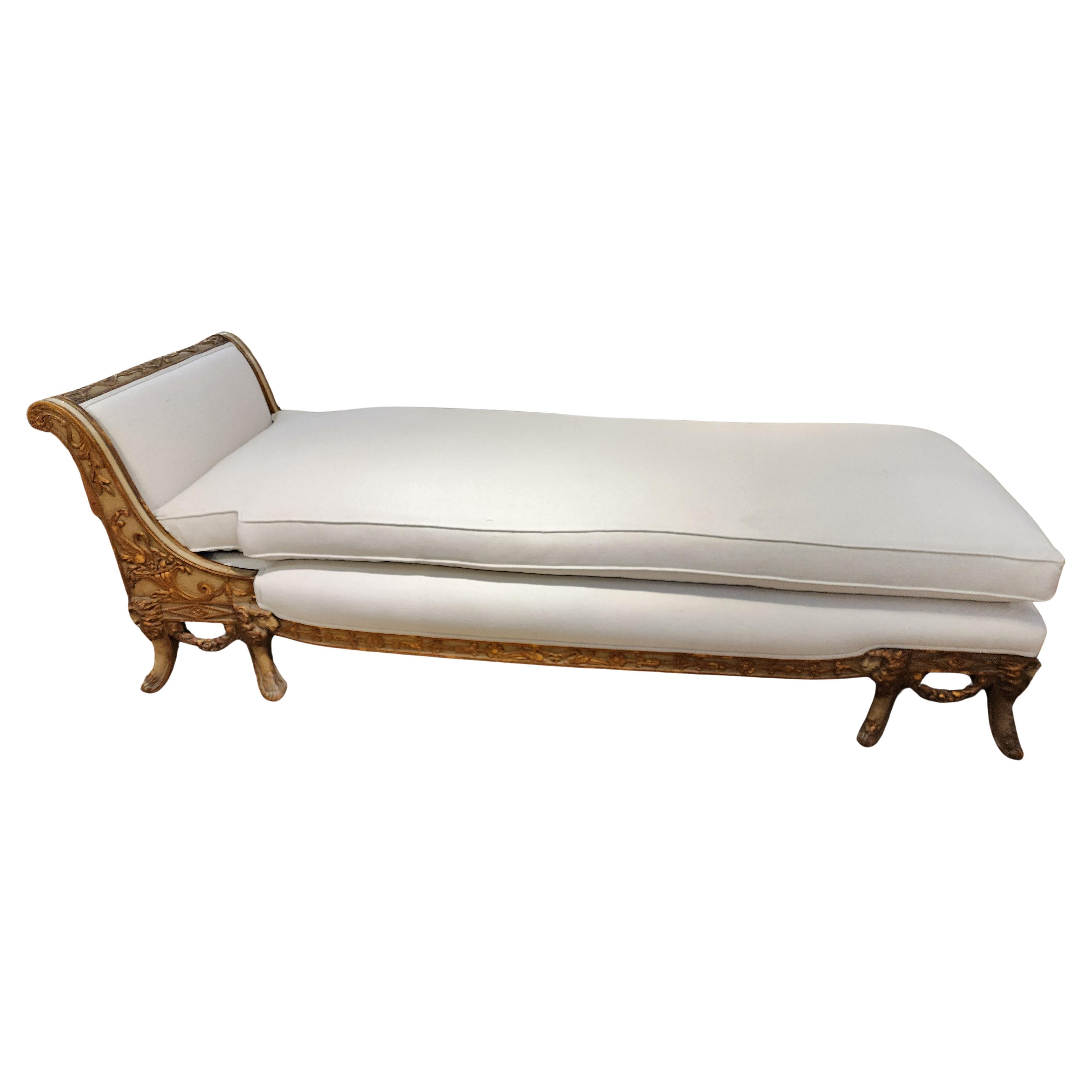 A fantastic and whimsical chaise lounge. Hand carved with a beautifully patinaed green paint and gilded accents. This truly is large enough for a person to sleep on should one need a small bed. With carvings of cornucopias, swags, Lions heads and