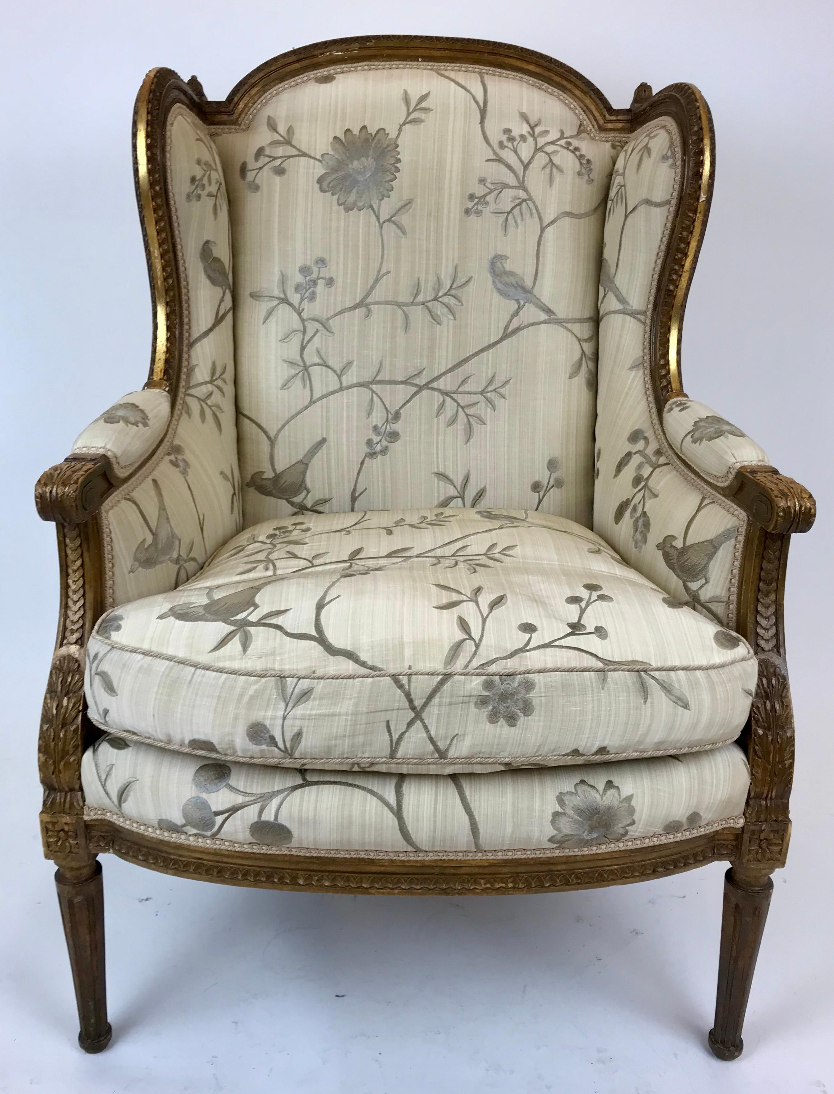 This hand carved Louis XVI style giltwood armchair features classic motifs including acanthus leaves, rosettes, and fluted tapered legs.