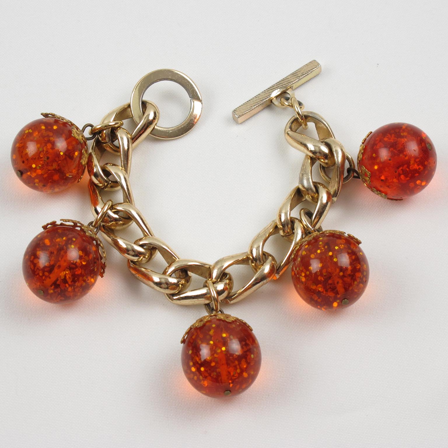 This lovely Bakelite and metal chain-link bracelet features a large gilded aluminum chain with five giant Bakelite bead charms in a transparent orangeade. This Prystal quality Bakelite is complimented with gold flakes inclusions. The bracelet has a