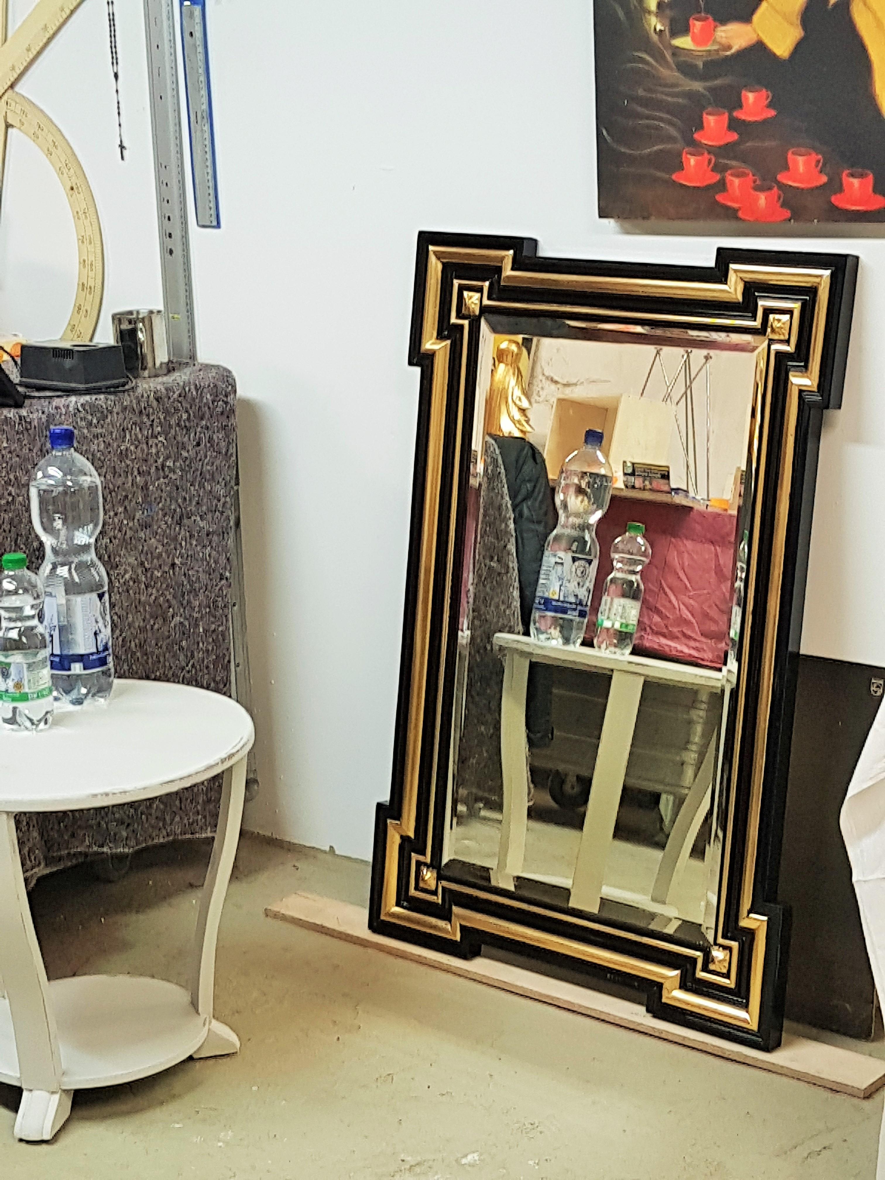 19th century French gilded mirror was handcrafted during the Napoléon III period, and features a subtly embossed plaster design overlaid with gold leaf and black lacquer. Restored condition.
        