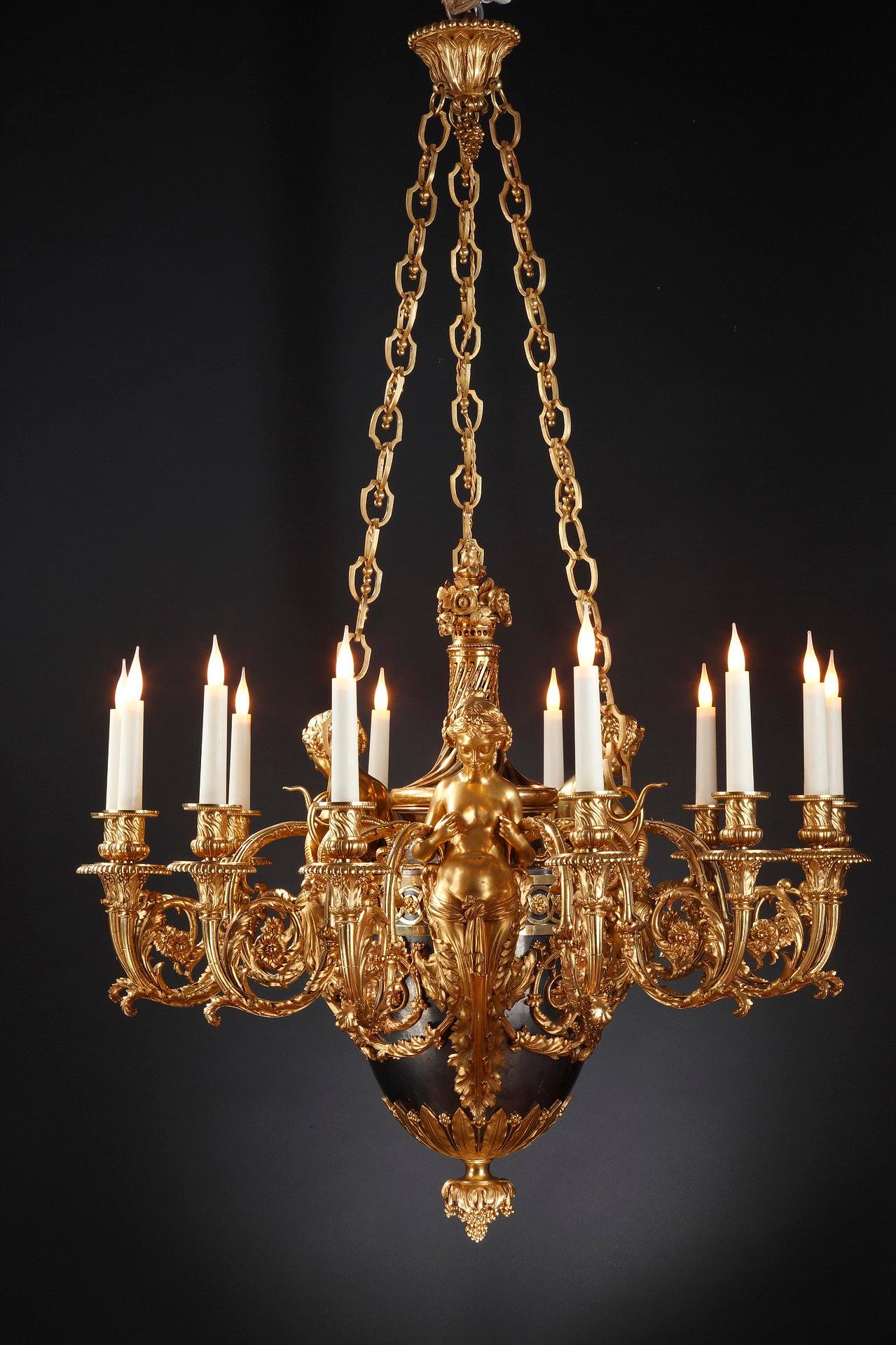 Porter la marque BY (pour A.E.) Beurdeley)
Magnifique lustre en bronze ciselé, doré et patiné, à douze lumières. Le fût est constitué d'un vase de forme ovoïde en bronze patiné bleui 