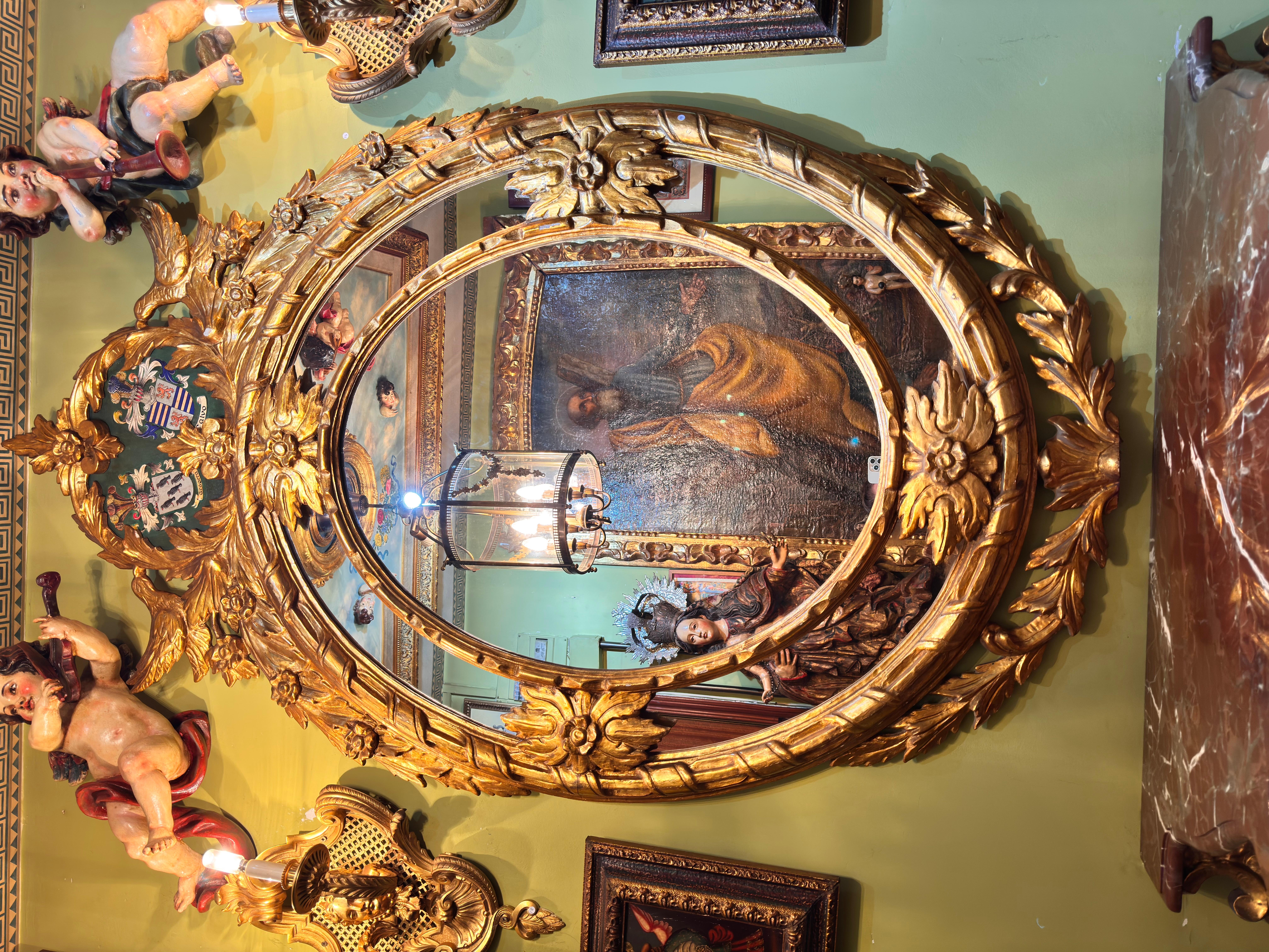 Mesa Consola Barroca Dorada con Mármol Rojo y Espejo Tallado con Escudos, S. XIX
Este extraordinario conjunto se compone de una consola con tapa de mármol rojo veteado y un gran espejo con marco tallado y dorado, fabricados en la España del siglo