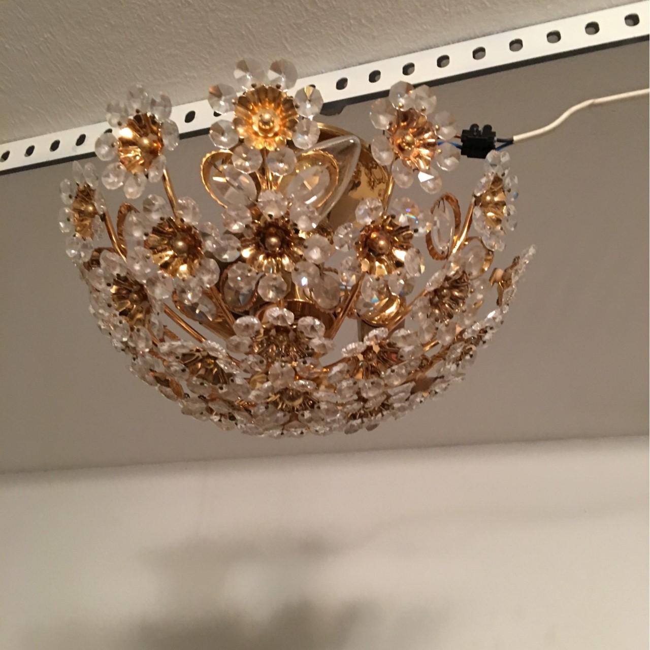 Chandelier made of Gilded Brass Crystal Flowers from Palwa. Manufactured in the late 1960s or very early 1970s.
The fixture requires three European E 14 candelabra bulbs, each bulb up to 40 watts. In working condition. Equipped with original 20th