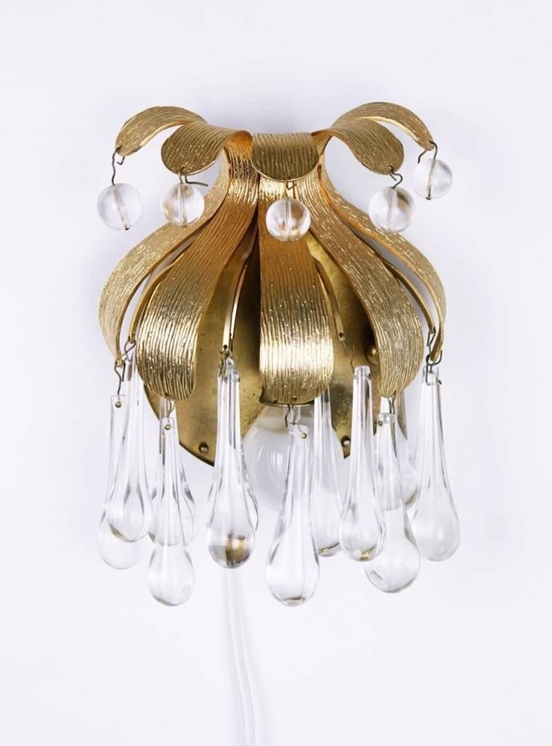 A stunning pair of sconces, made by Palwa, Germany, circa 1970-1979. It’s composed of Murano tear drop Crystal glass pieces on gilded brass frame.
Best of the 1970s from Germany.
Each sconce needs one E14 bulbs.