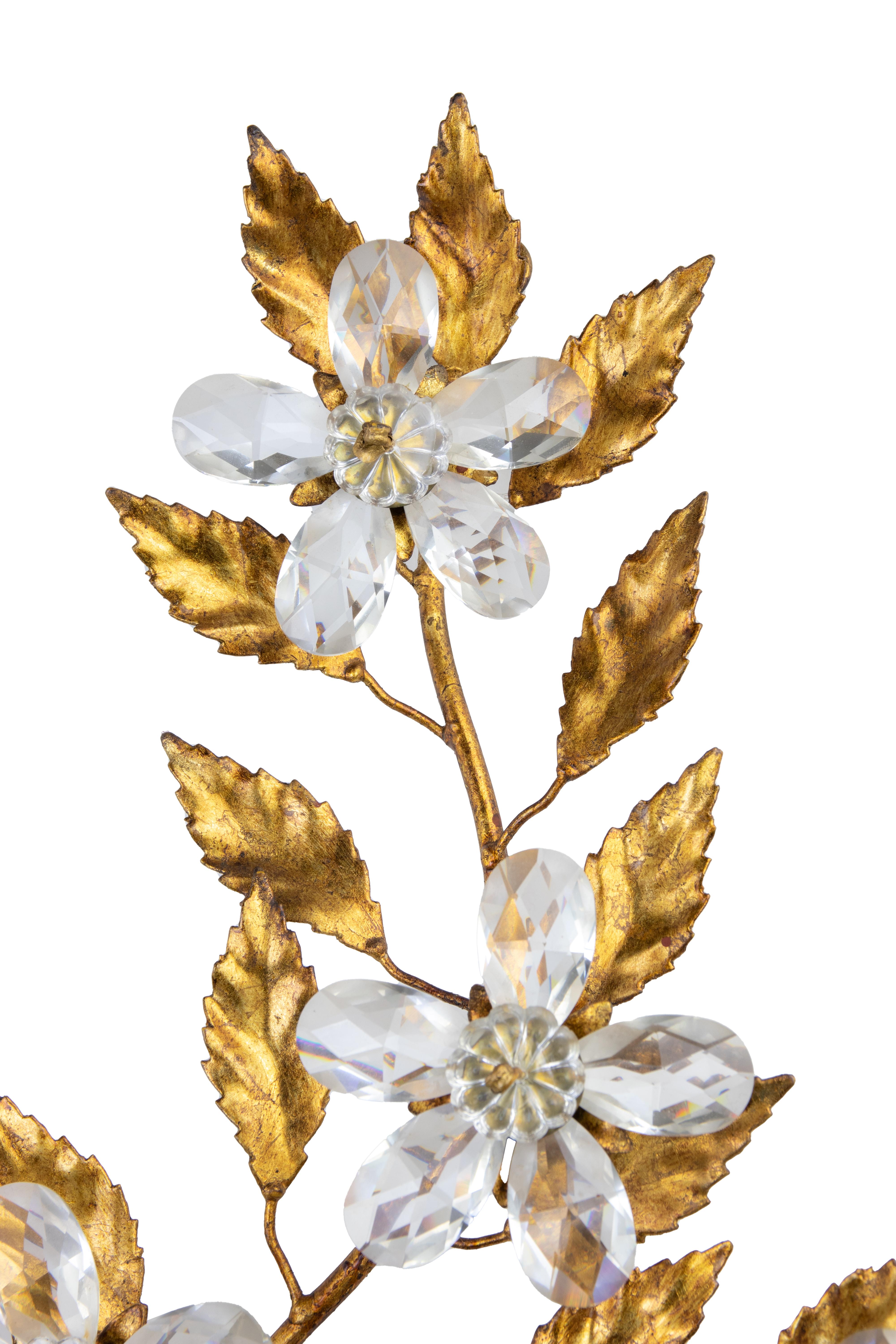 Applique en laiton doré dans le style de Hans Kogl, fin du 20e siècle.

2 lumières, avec des gouttes de cristal en forme de fleurs.

60 x 48 cm.

Très bon état. 