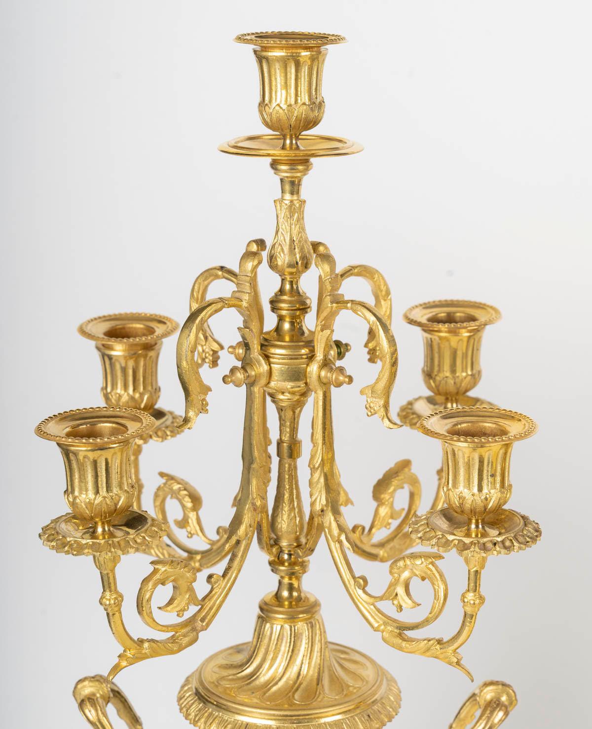 Juego de chimenea de bronce dorado y porcelana dorada y esmaltada de Sèvres, época de Napoleón III, siglo XIX, reloj central y dos candelabros, siglo XIX.

Reloj: Alto: 60 cm, Ancho: 31 cm, Fondo: 20 cm
Candelabro: A: 58 cm, P: 26 cm

Ponte en