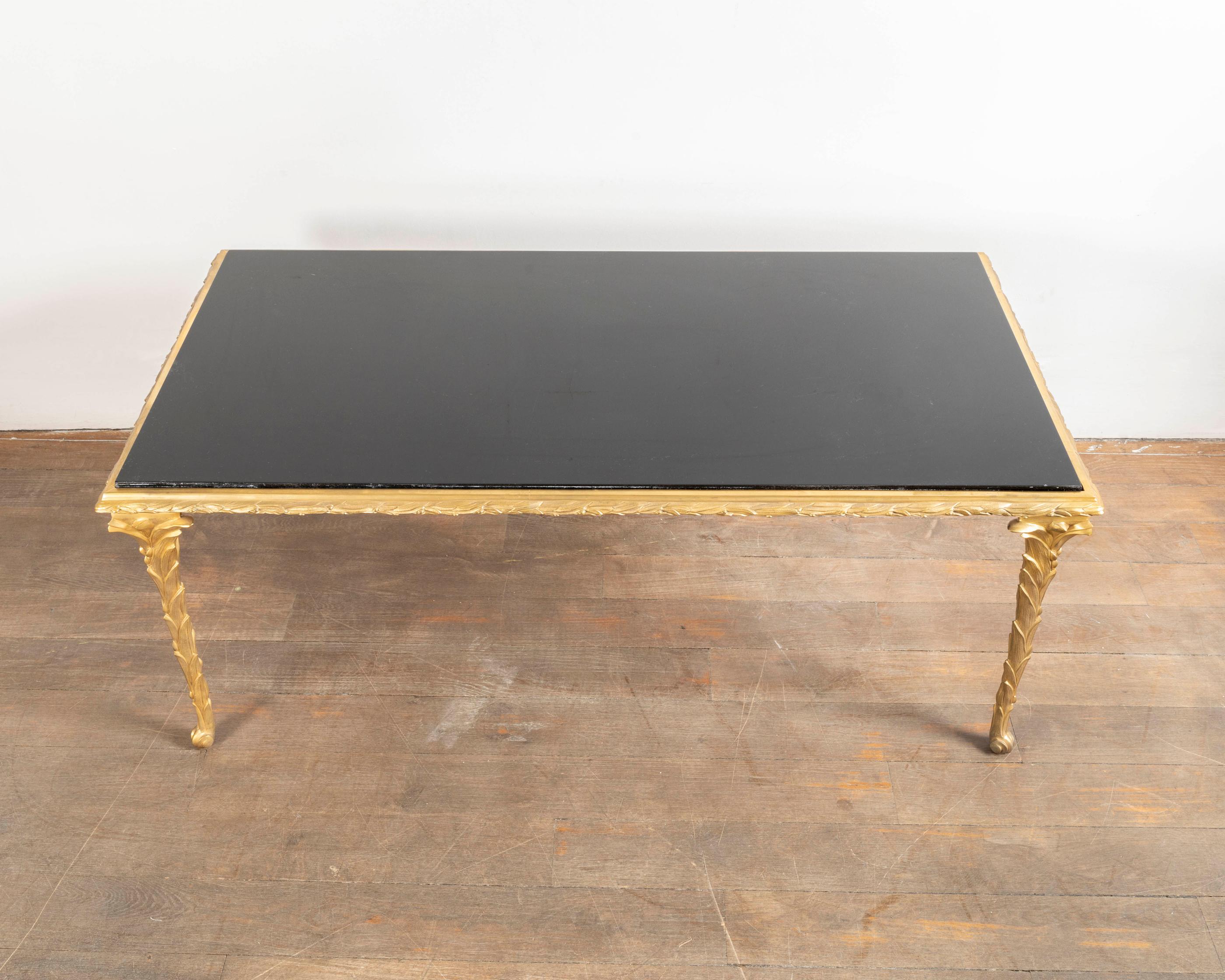 Coffee table, gild bronze feet and frame with palm leaf motive, black lacquer top,
Maison Baguès, France, circa 1950.