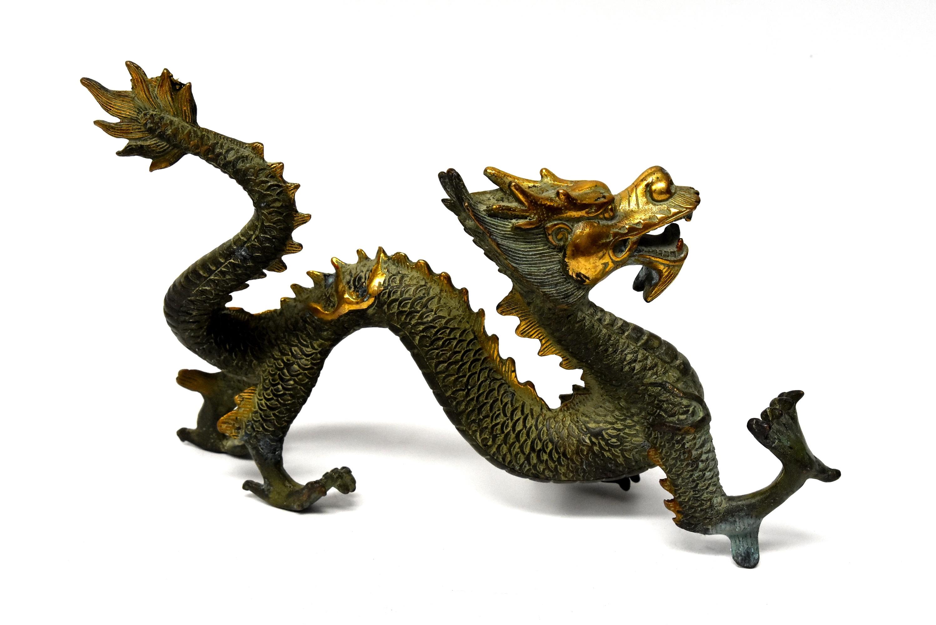 A handsome gilded green bronze dragon. The dragon is the symbol of the Chinese emperor. It represents power, strength and prosperity. This sculpture captures the dragon in motion of reaching forward, symbolizing attaining goal. Beautiful gilding