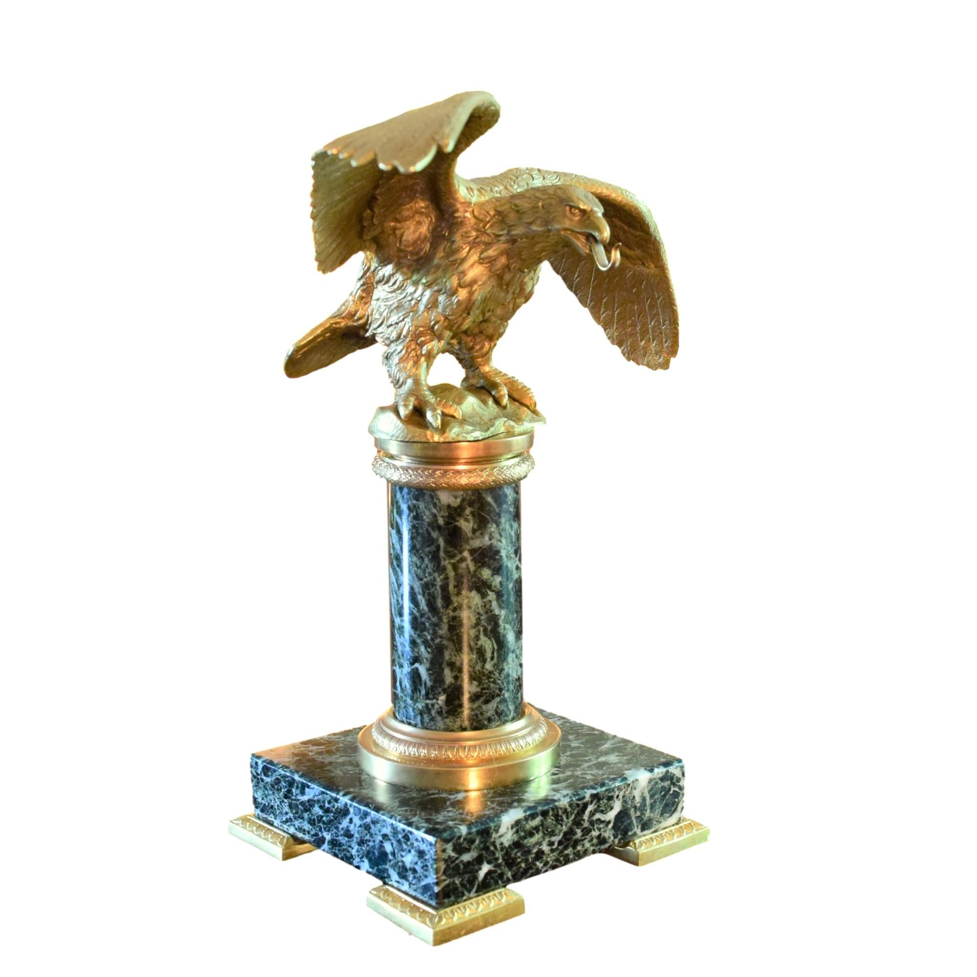 

A Chased and Gilded Eagle Pocket Watch Holder standing on a Green Marble column, itself decorated with gilded bronze details.

This particular eagle is a smaller edition of an eagle used under Napoleon the First’s Flagpoles.
Napoleon chose for his