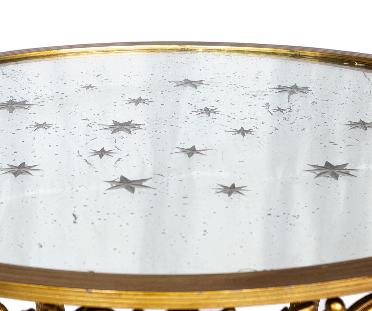Bronze circular gold coffee table, four short legs and mirrored top with encrusted stars in a modern twist of Louis XV style.

