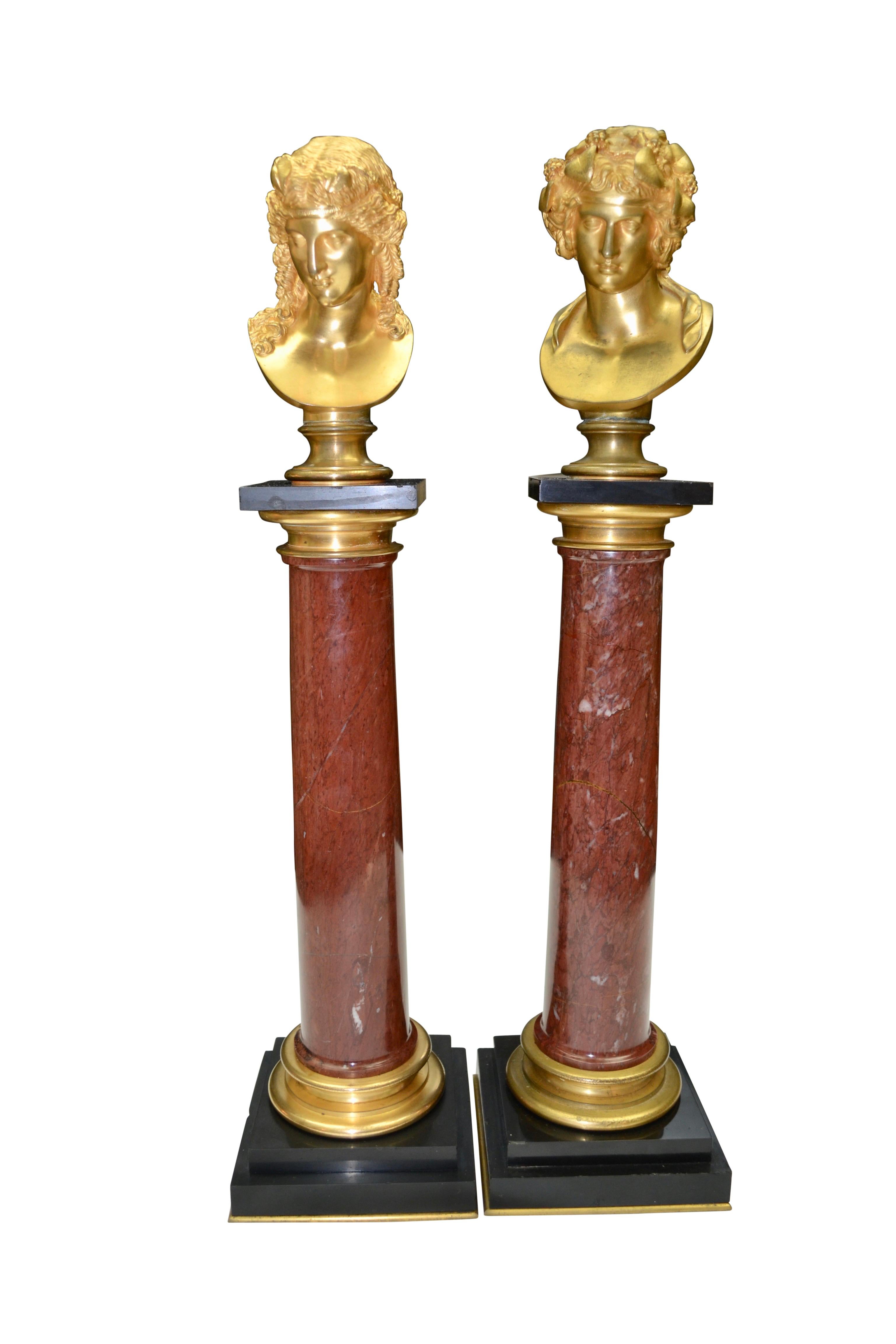 A fine pair of gilded bronze sculptural busts mounted on top of circular rouge marble columns with gilt capitals and gilt bases, the columns mounted on rectangular black marble bases. 

The busts represent Bacchus and Ariadne. The myth of Bacchus