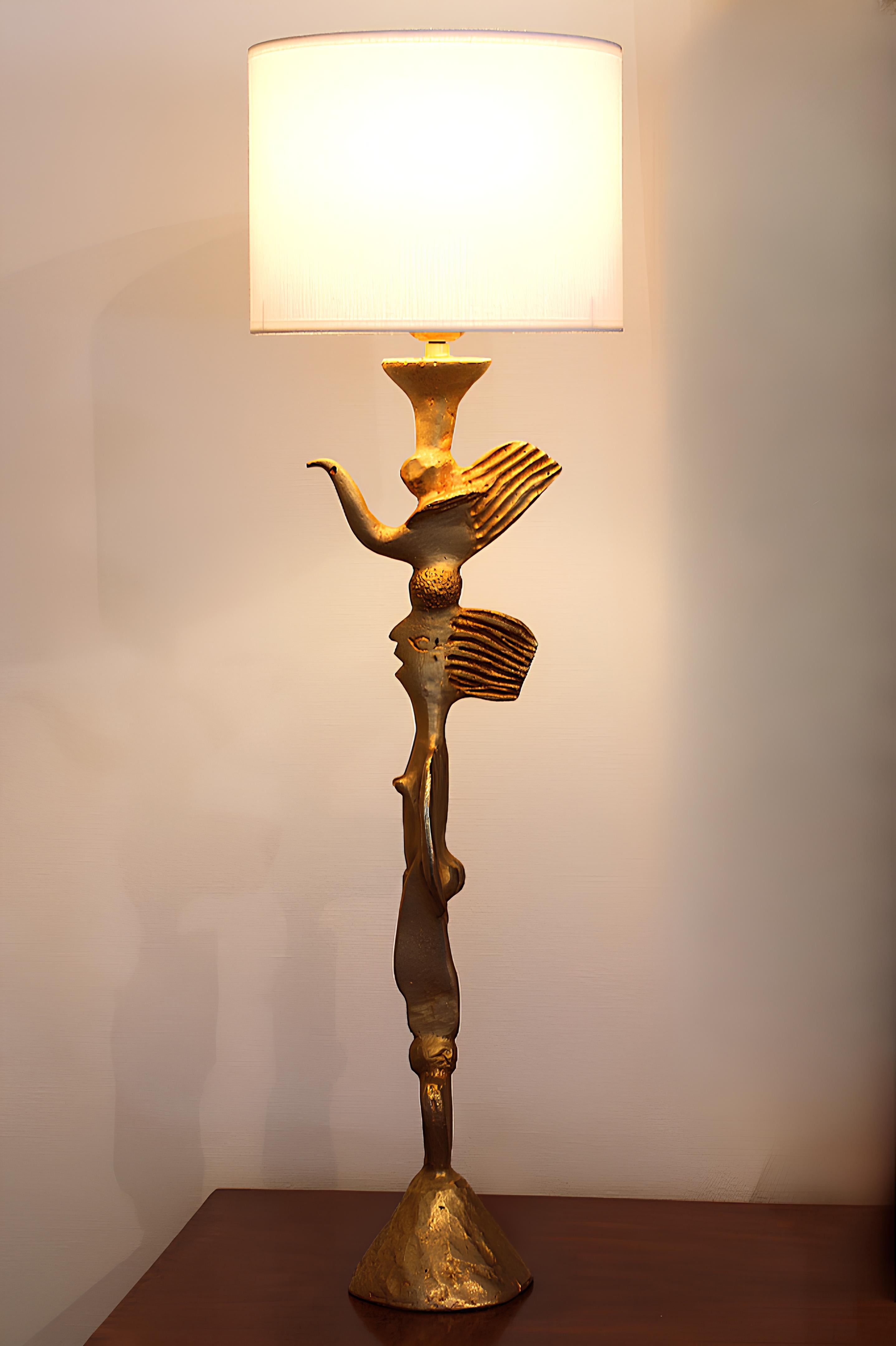 Gilded bronze lamp by Pierre Cazenove (1943) for Fondica.
Totem model with zoomorphic and anthropomorphic decoration.
Circa 1980.

Height with lampshade : 67 cm
Height without lampshade : 57 cm

Width of lamp base : 15 cm
Lampshade diameter : 20 cm