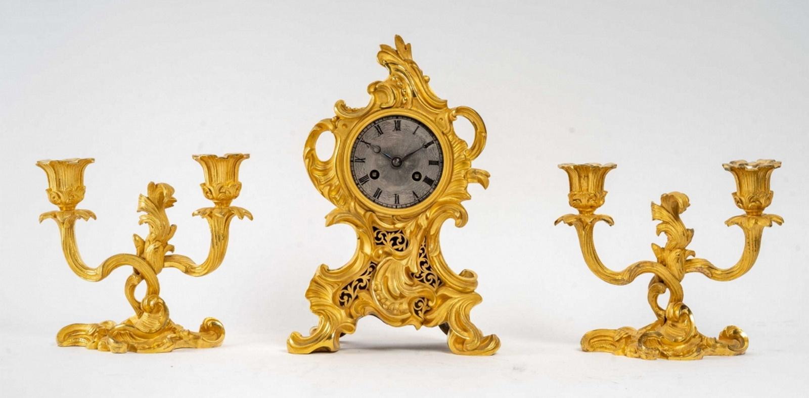 Gilded bronze mantel set - Louis XV style - Napoleon III period - 19th century
It is composed of a clock resting on four arched feet, with rocaille decoration, as well as a pair of candelabras with two intertwined arms of light with very pronounced