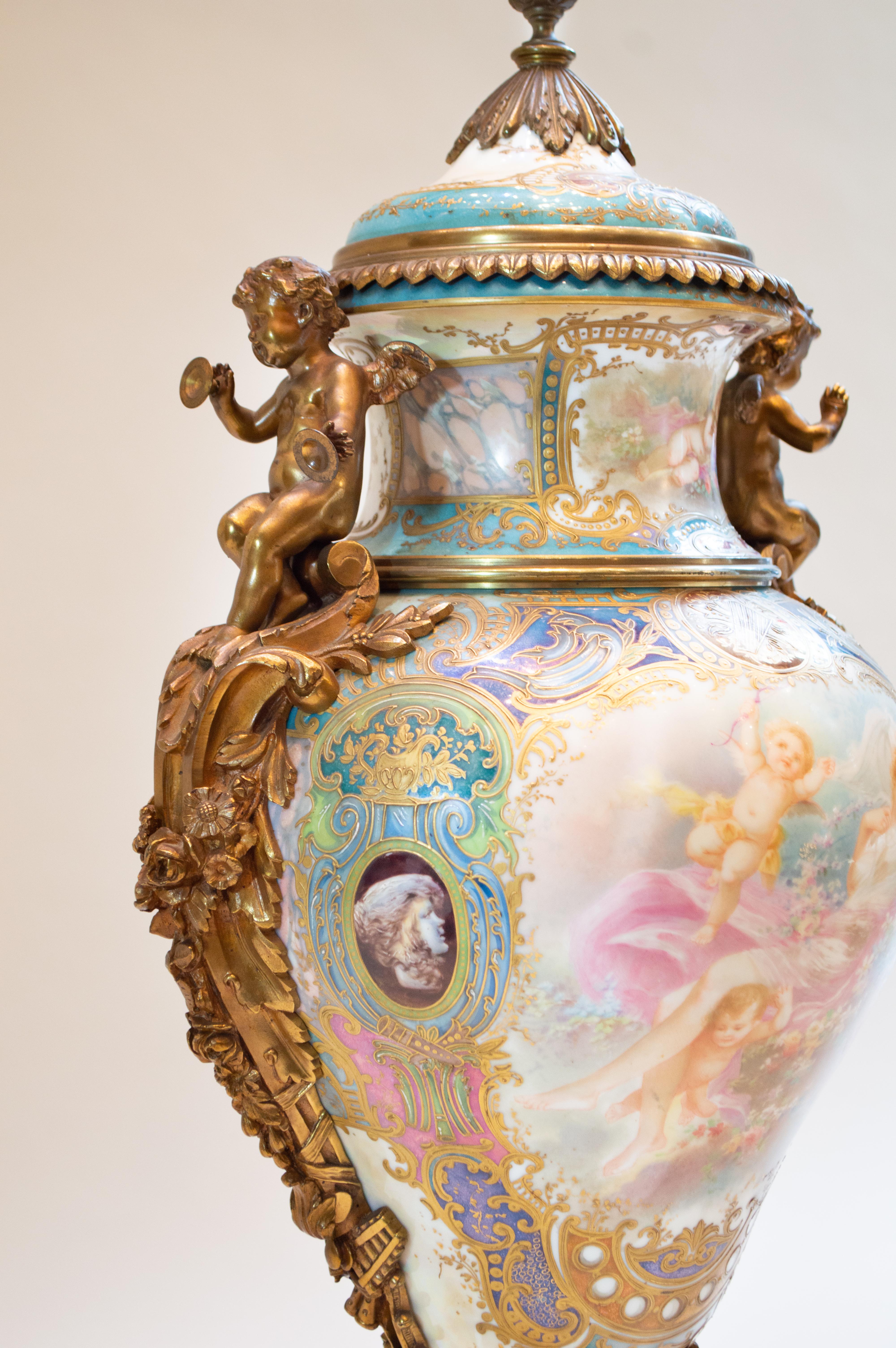 Late 19th century, the vases hand painted with scenes of maidens and cupids, the reverse with landscapes, beautifully gilded throughout on lustre-ground.
 