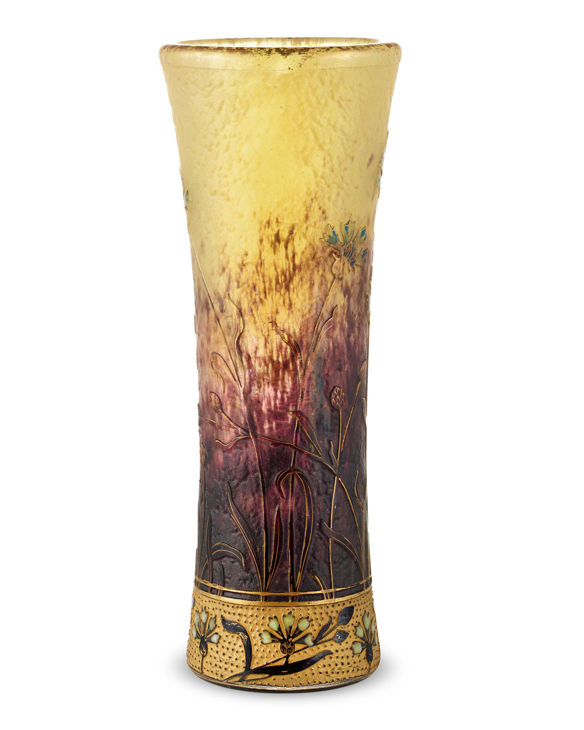 Diese Kamee-Vase wurde von dem unnachahmlichen Daum Nancy entworfen und zeigt die hervorragende Qualität und Detailgenauigkeit, für die das Unternehmen bekannt ist. Grüne, mit Säure geätzte Blumen erheben sich aus dem leuchtend roten und gelben