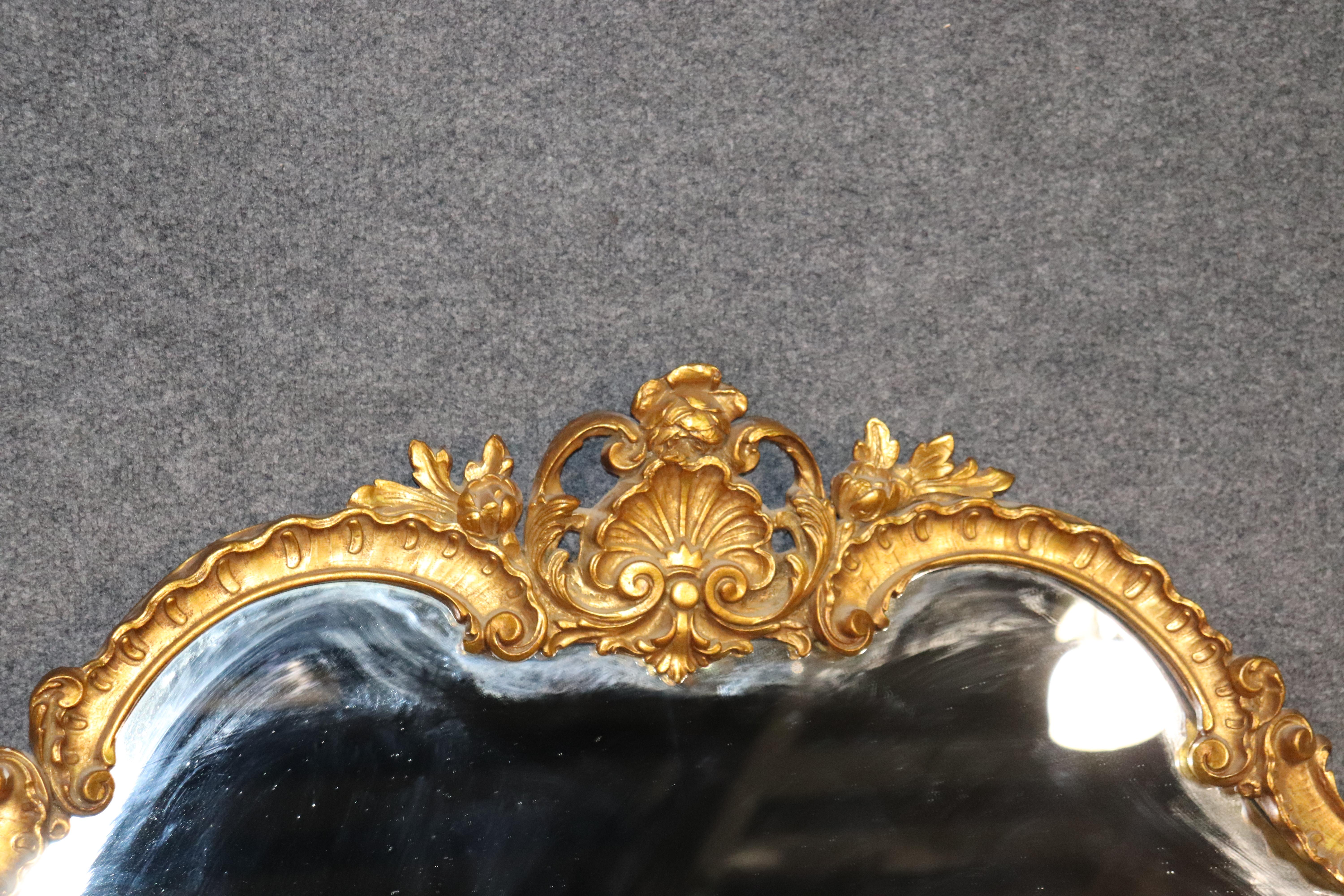 This is a fine quality 1940s era Decorative Arts Louis XV mirror. This is perfect for use over a mantel (fireplace) or a buffet or sideboard. The mirror is genuine gold leaf and has a nice patina to it. The mirror measures 55 wide x 44.5 tall x 3