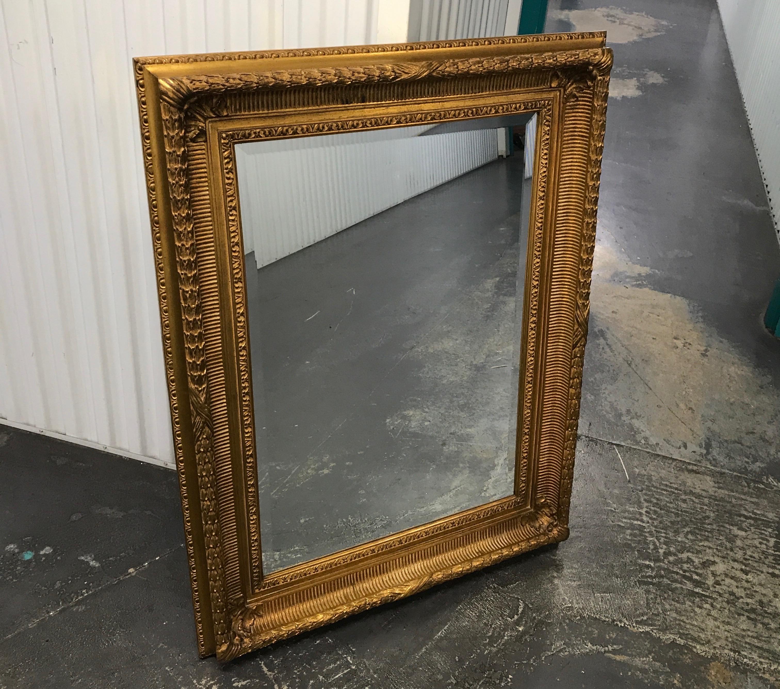 Traditional carved and gilded beveled rectangular mirror by Carver's Guild.