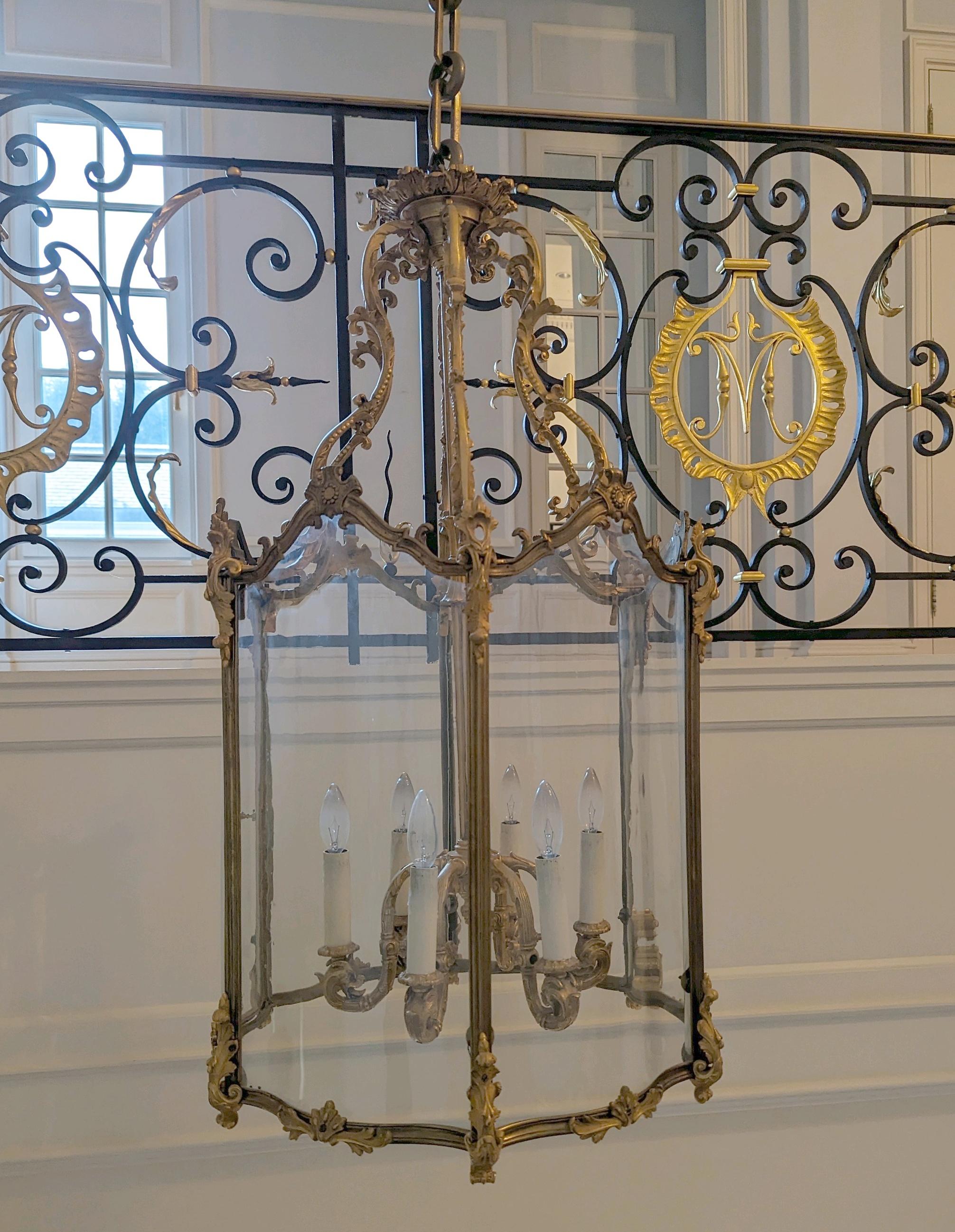 Lanterne suspendue ornée en bronze doré avec six bras de lumière et des panneaux en verre clair incurvé. Elle a été récupérée dans une propriété située à Greenwich, dans le Connecticut. Bon état avec une usure appropriée due à l'âge. Un disponible.