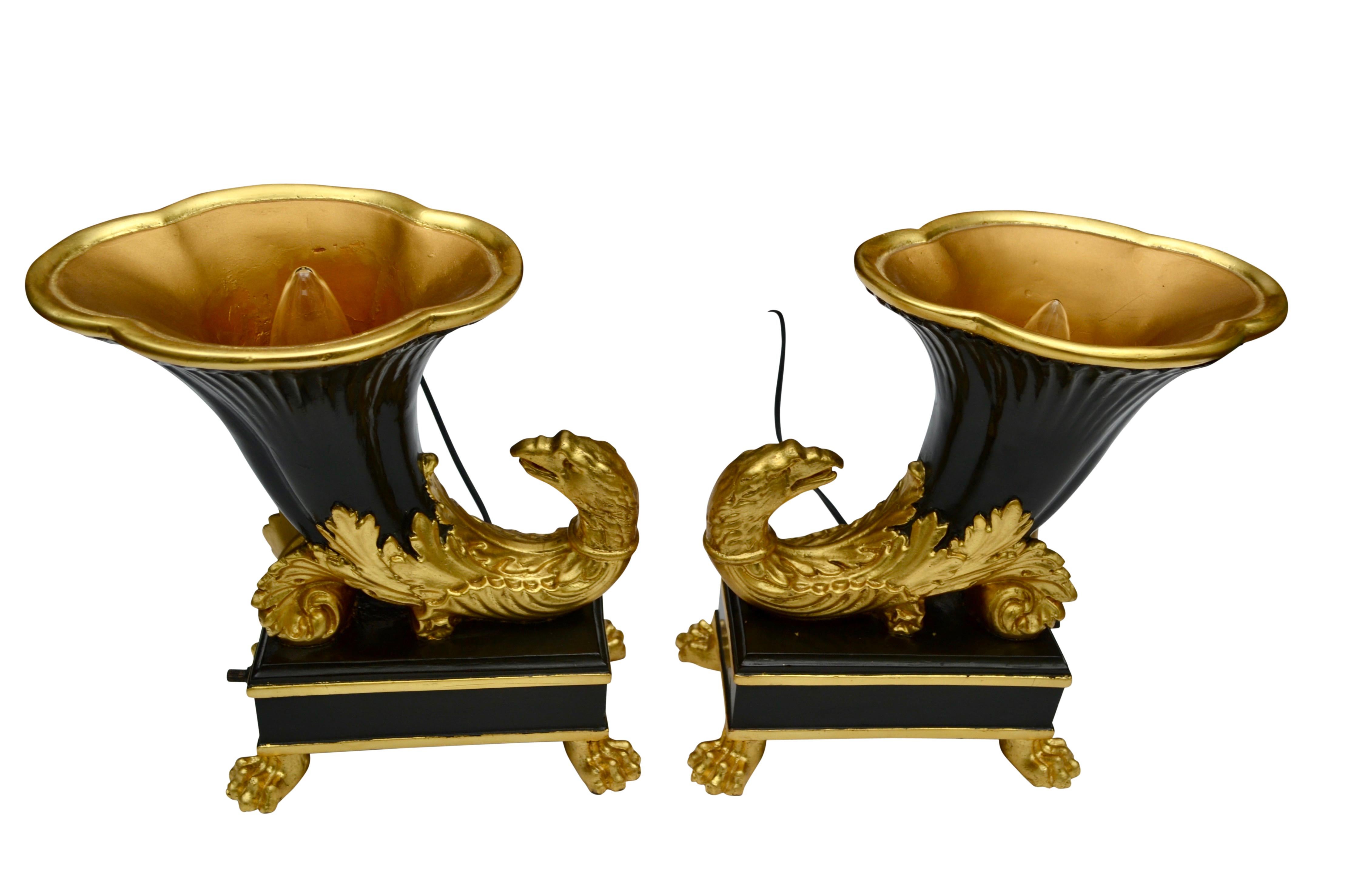 A pair of modern composition up lights modelled after classical Greek Rhytons; partially gilded and painted in faux bronze; likely American, early 20th century.
  
