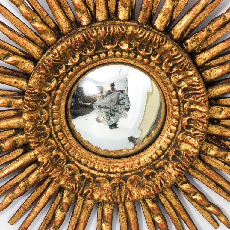 Spanish sunburst convex mirror in giltwood, circa early 20th century. Please note that the mirror itself has wear consistent with age including cracks in the silver foil.