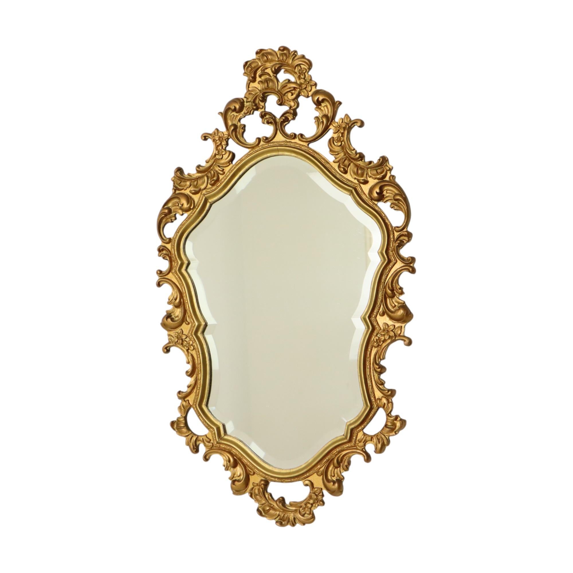 Beautiful gold-colored wooden mirror with fantastic facet-cut mirror plate, entirely in rococo or baroque style, classic crested mirror made in Belgium in the 1960s, the design is attributed to Deknudt.

Belgian house Deknudt, specialized in mirrors