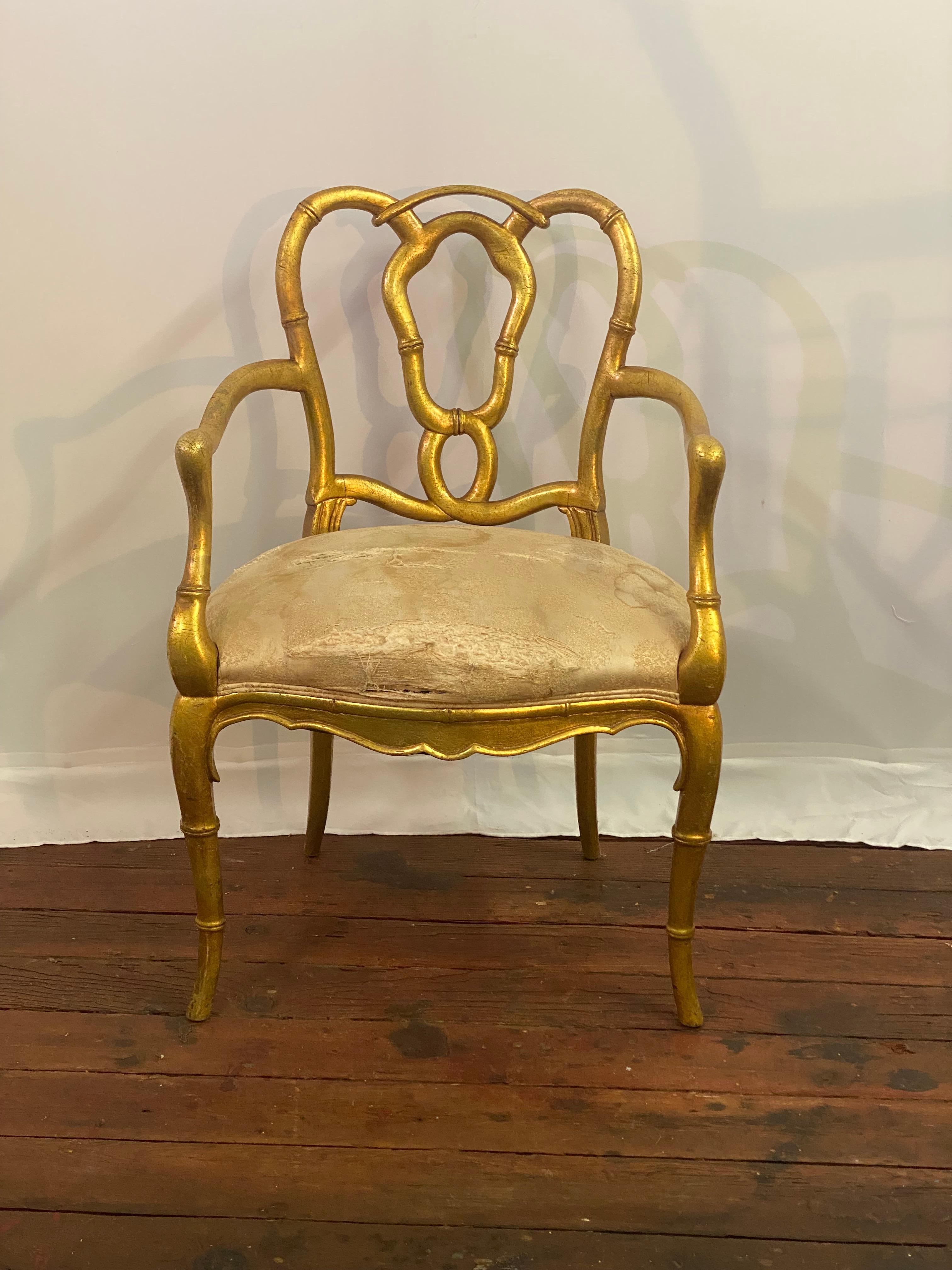Ein eleganter, vergoldeter Stuhl aus Bambusimitat mit gepolstertem Sitz. Die Merkmale des Einzelstuhls  ein wunderschön geschnitzter, durchbrochener Rückenrahmen mit einer sehr dramatischen Armlehne. Warme Patina auf der Vergoldung. Möglicherweise