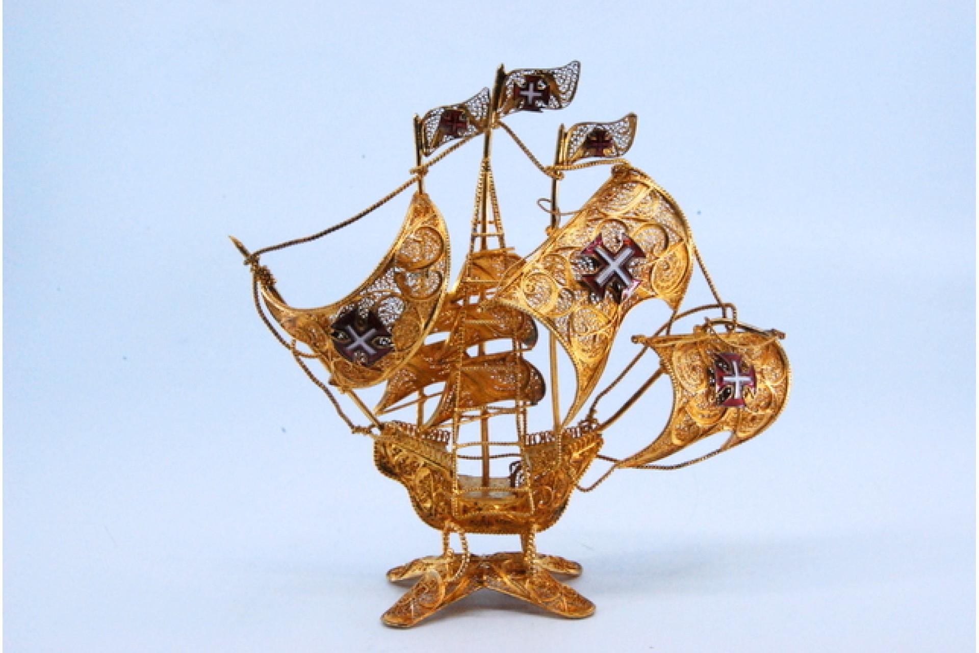 Description: Caravel in gilded filigree silver with enameled crosses and resting on a cut-out base. Metal: Silver. Origin: Portuguese. Mark: Absent. Weight: 83.05 grams. Dimensions: 18x3.7cm. Content: 925/1000. Assay Mark: Absent. Additional