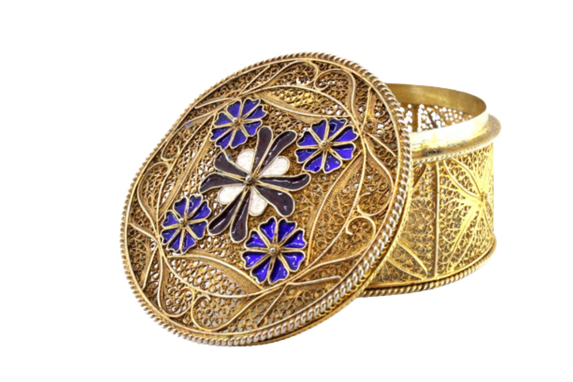 Descrizione: Scatola in filigrana d'argento dorata con fiori smaltati sul coperchio, appoggiata su tre piedi sferici. Metallo: Argento. Origine: Portoghese. Marchio: javali II Titolo. Peso: 167,42 grammi. Dimensioni: 6,5 cmx4 cm. Contenuto: