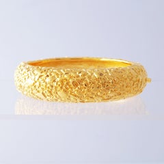 Pulsera brazalete con bisagra dorada y acabado texturizado de Kenneth Jay Lane, años 90