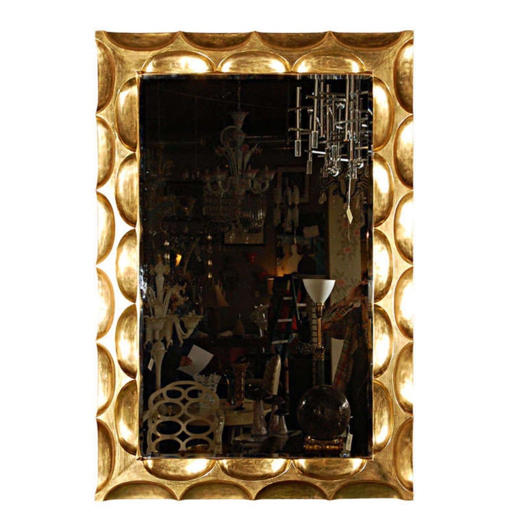 A sexy gilded hand carved honeycomb mirror by Bryan Cox. It is gilded in real 22-karat real gold (not imitation) and has a beautiful deep carved design. Mirror is beveled.