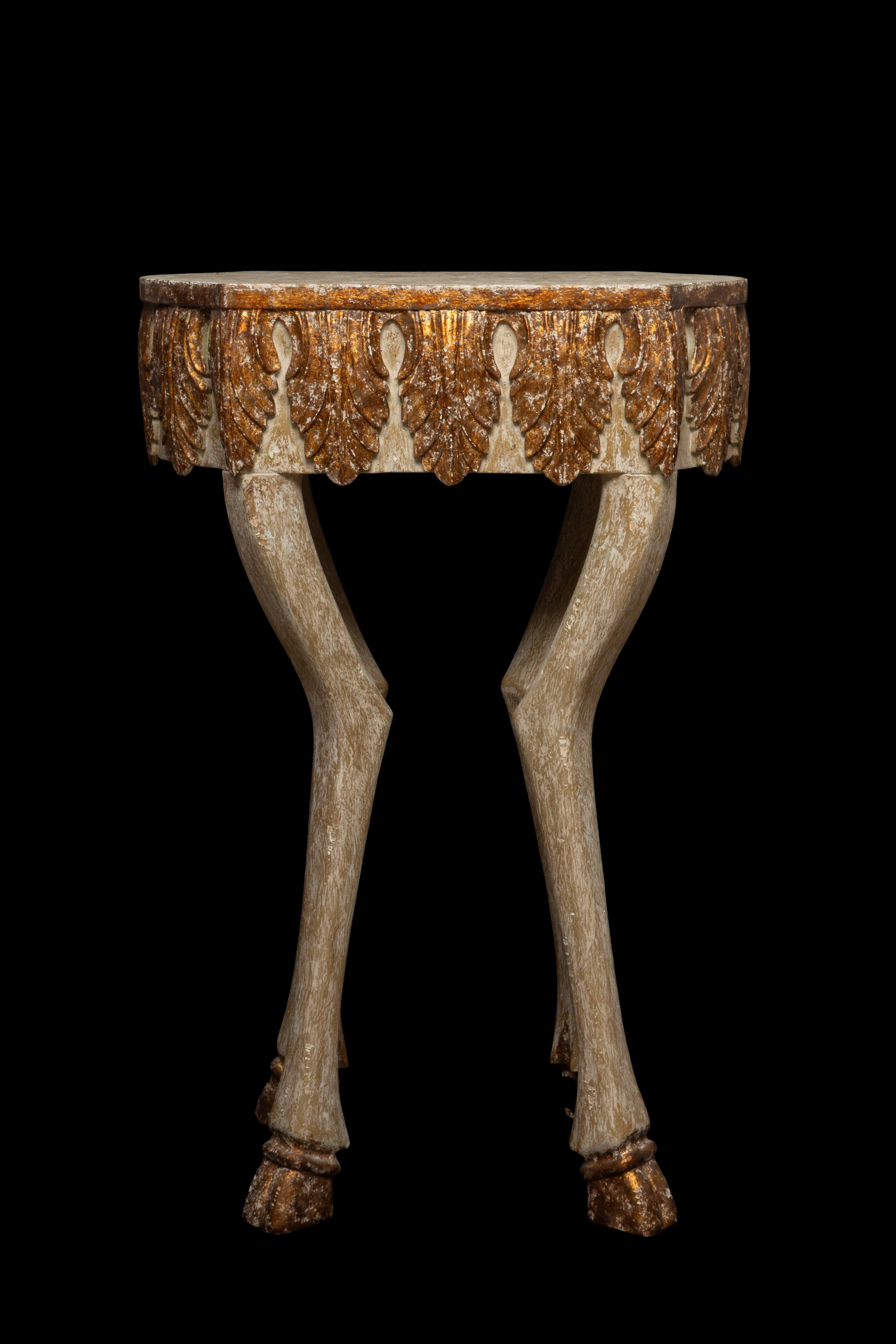 Exquisite Carved Wood Side Table featuring a stunning white-washed finish adorned with delicate gilded accents, all supported by intricately carved hoof legs. Crafted with meticulous attention to detail, this charming side table from the renowned
