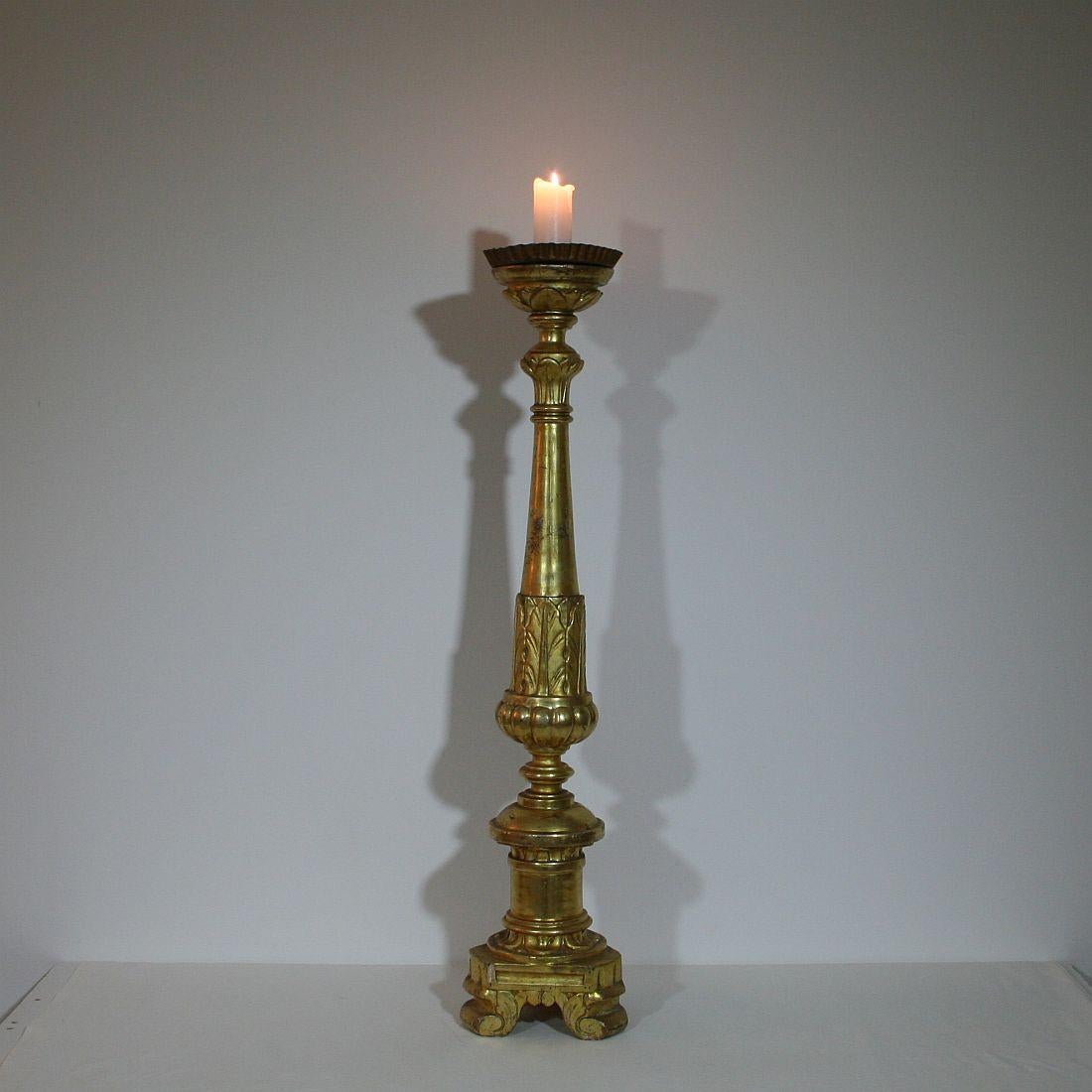 This giltwood Italian candlestick was originally used on the altar of a church. It was hand-carved and exquisitely gilded on only one side as a means of economy for the Church. Great piece.